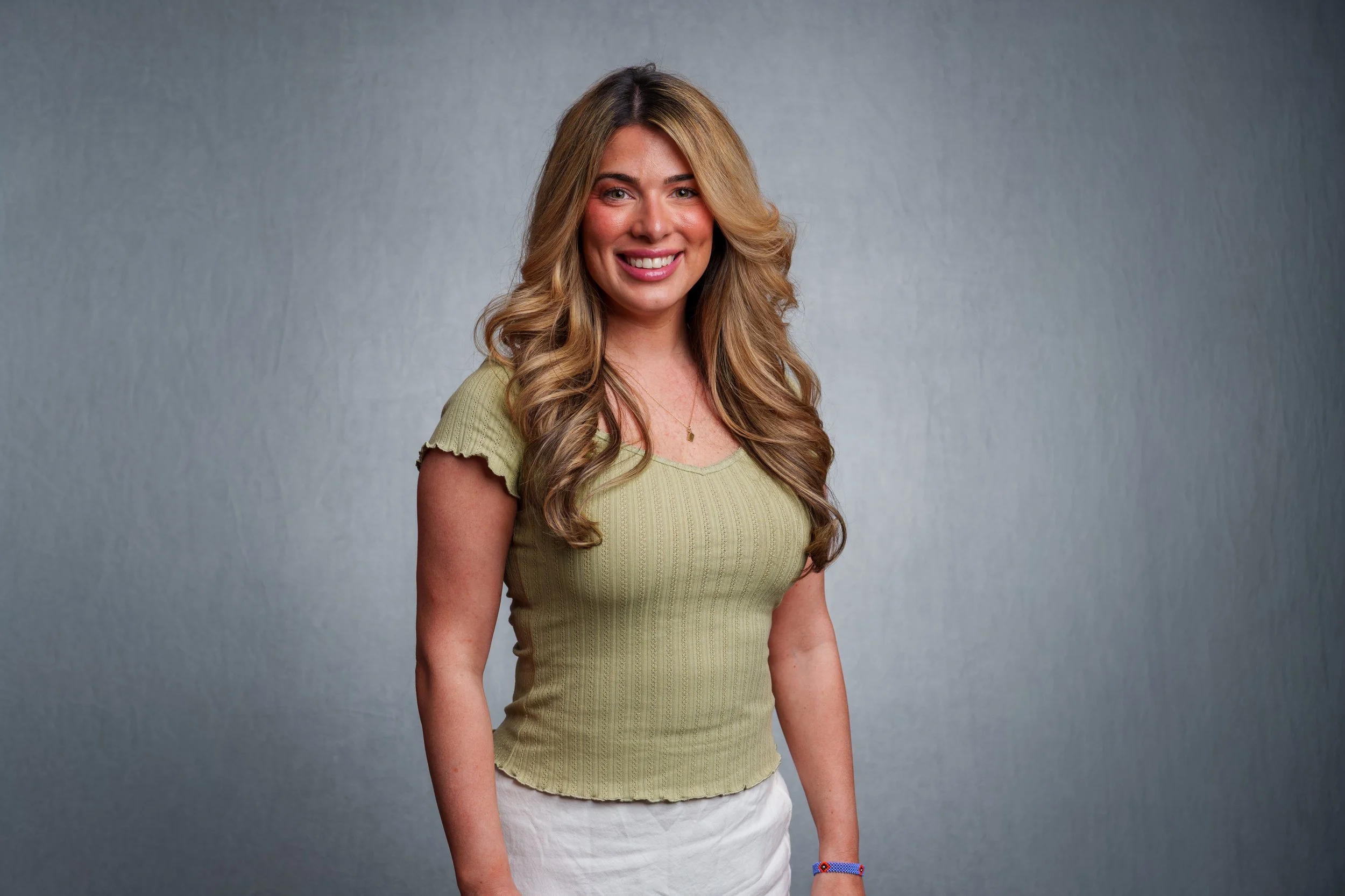 Professional employee portrait of a smiling woman photographed with studio lighting on a gray backdrop in Scottsdale, Arizona.