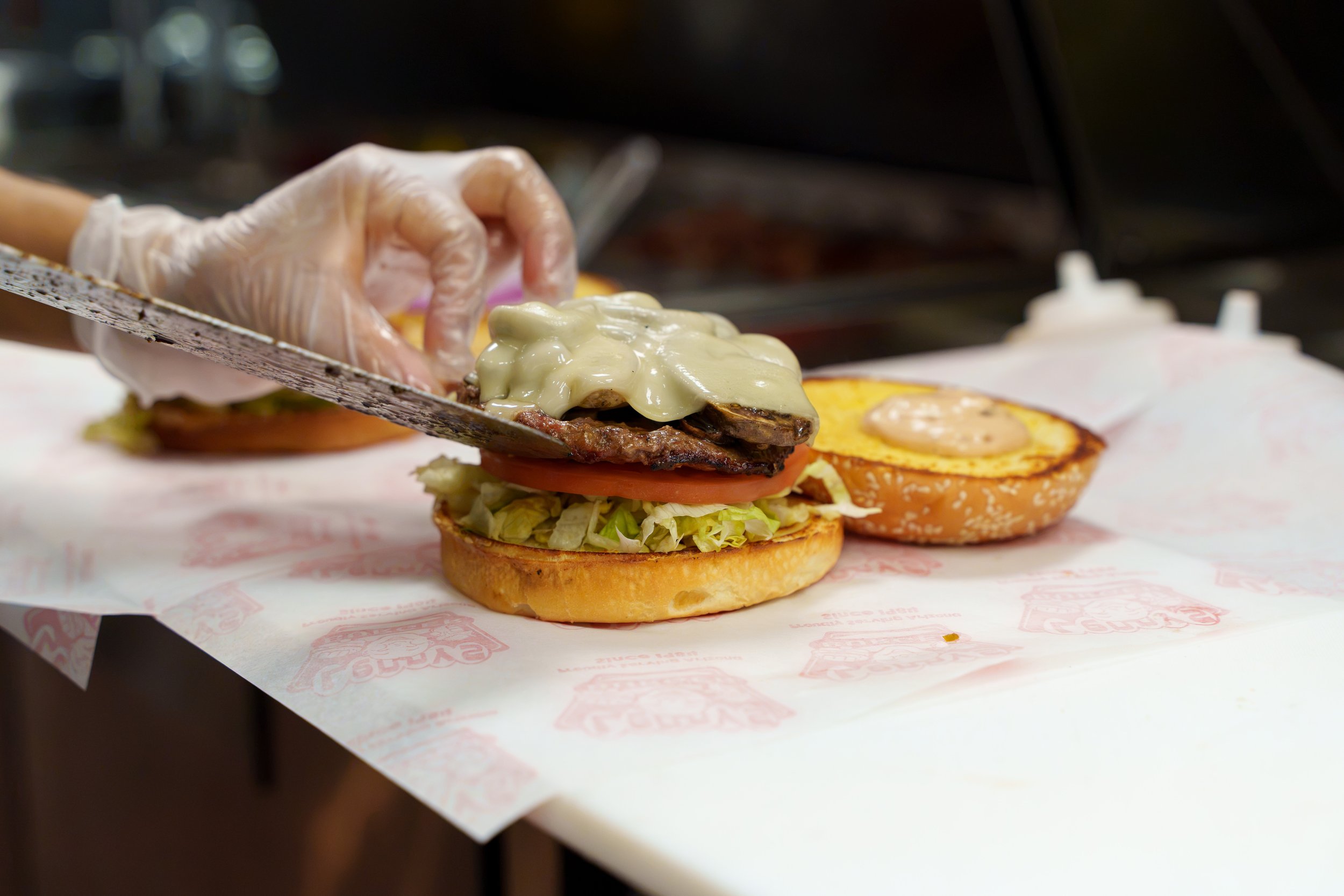 Burger being assembled during a restaurant food photography shoot in Phoenix Arizona