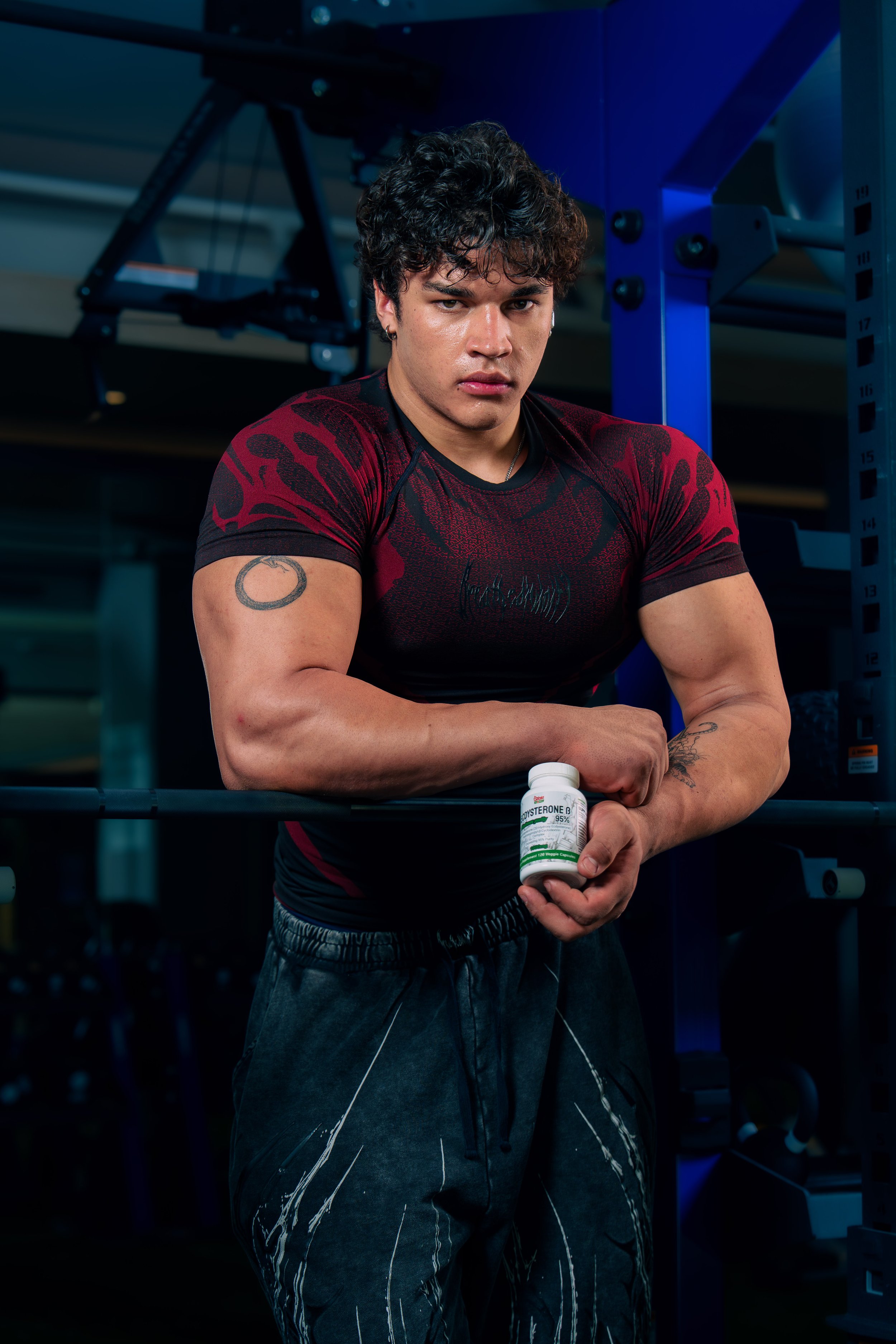 Fitness athlete holding a supplement during a commercial lifestyle photoshoot in a Phoenix gym