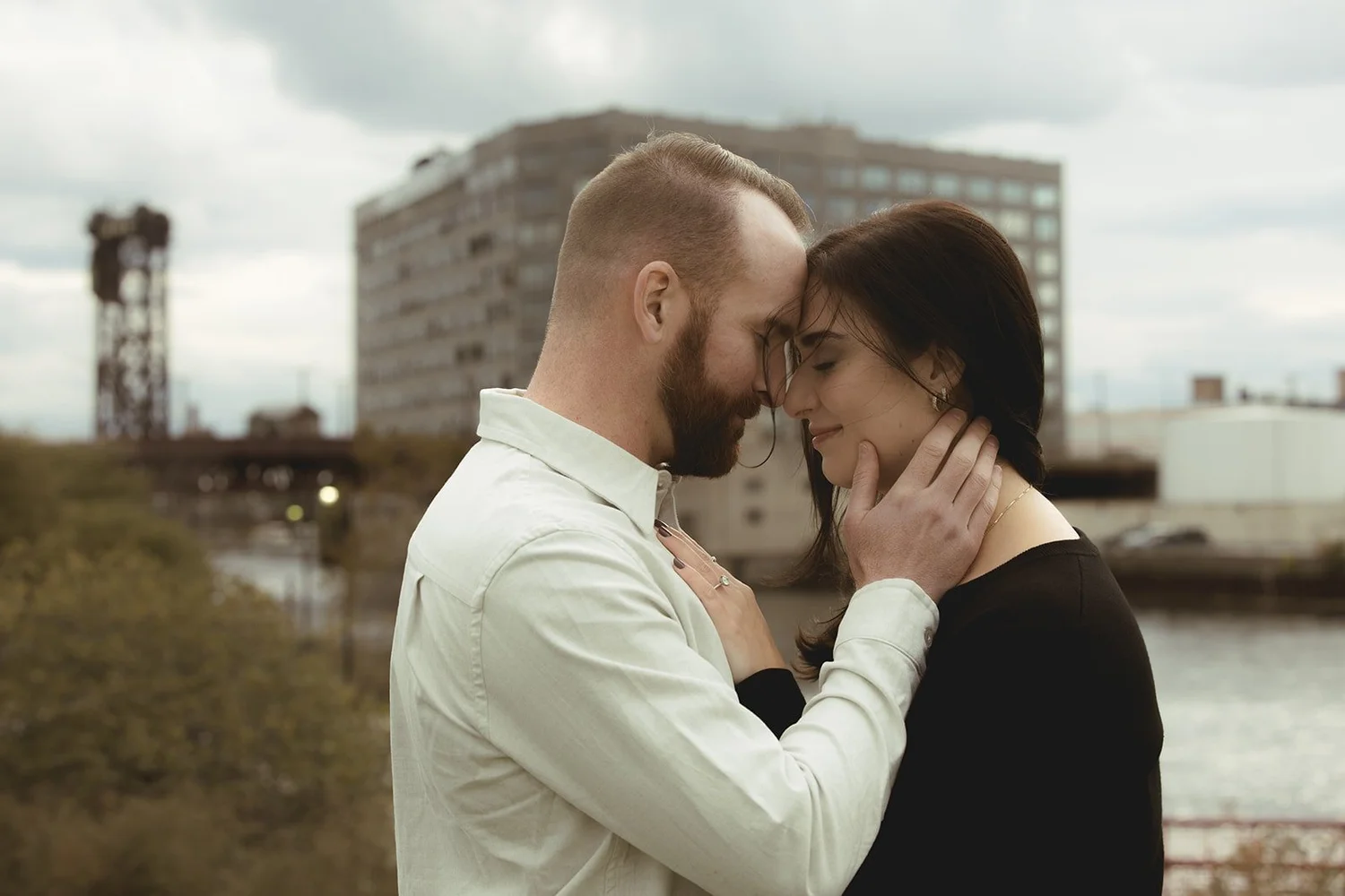Intimate couple portrait on Chicago bridge with downtown skyline at golden hour