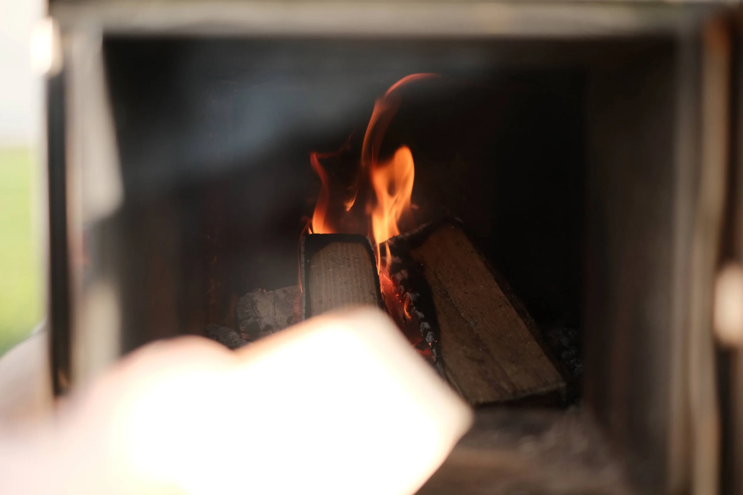 Premium kiln dried logs burning with a clean flame inside a wood fired sauna stove.