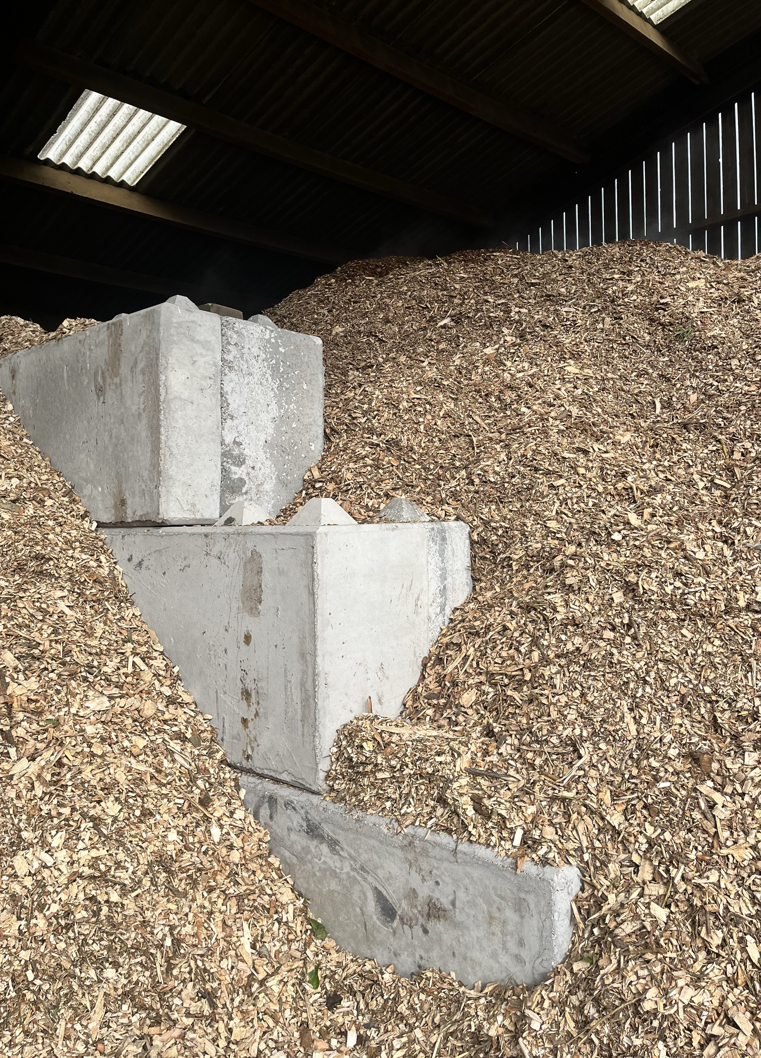 Concrete blocks and wood chips inside a storage shed or barn.