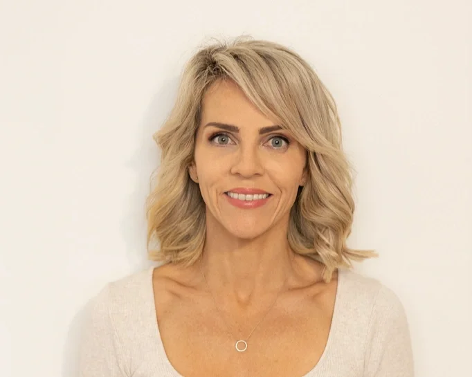 A woman with short blonde hair smiling