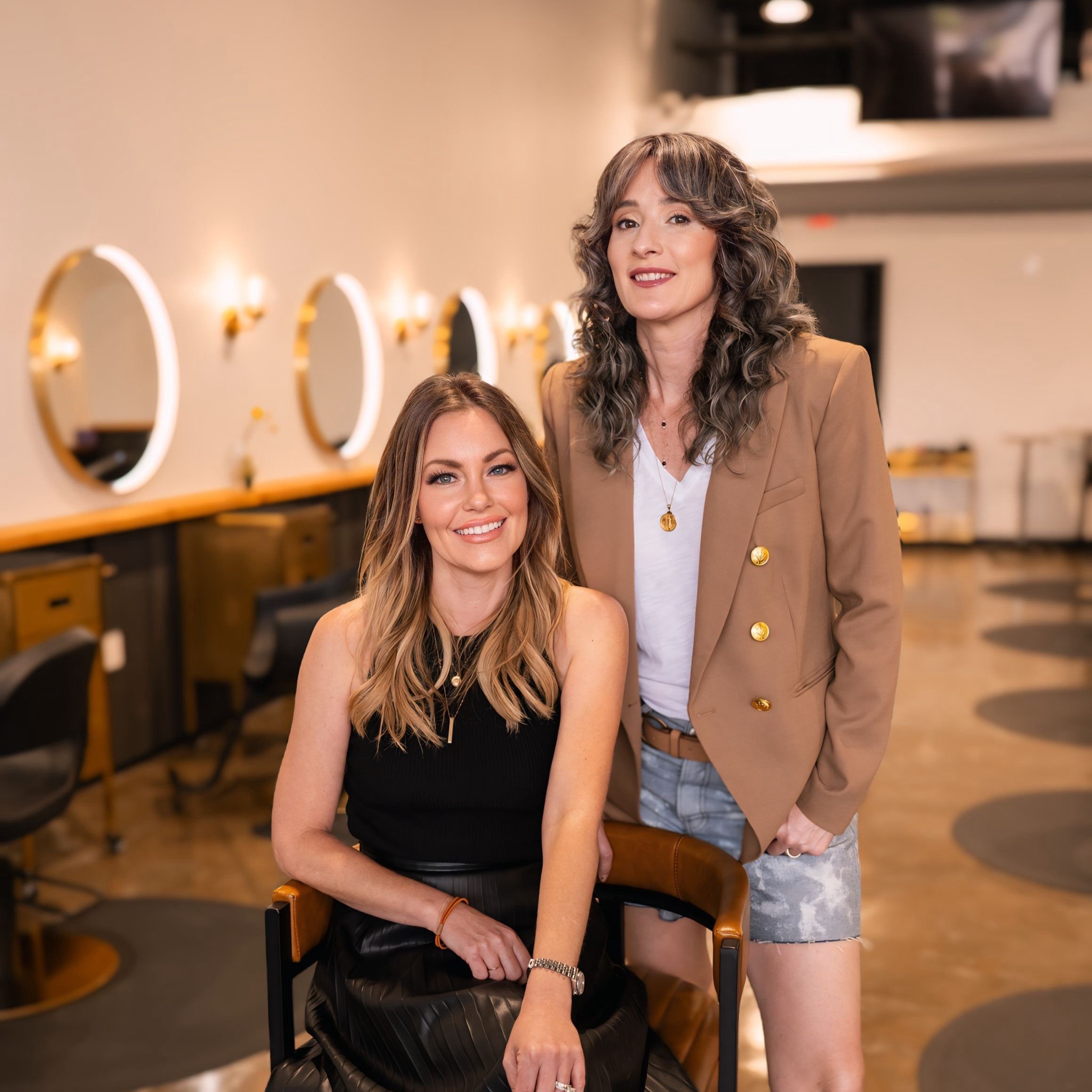 Two women Erica Keelen and Jessica Stokes owners of Studio Sage Hair Salon in salon setting