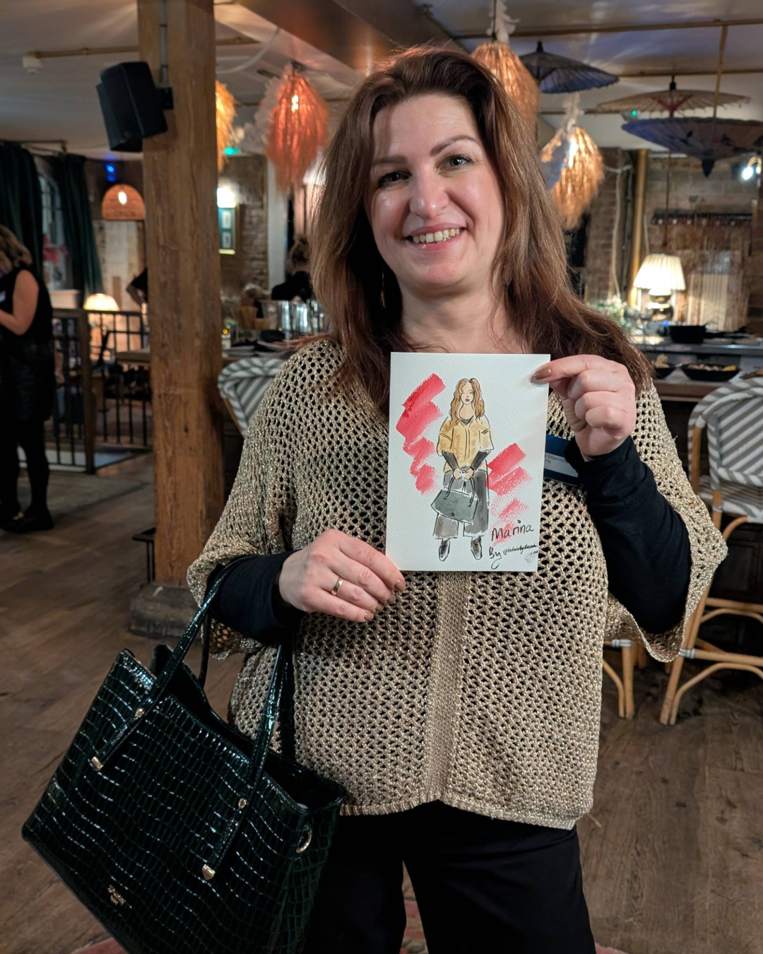 Lady holding of custom portrait of herself which was illustrated by Helen Ridley