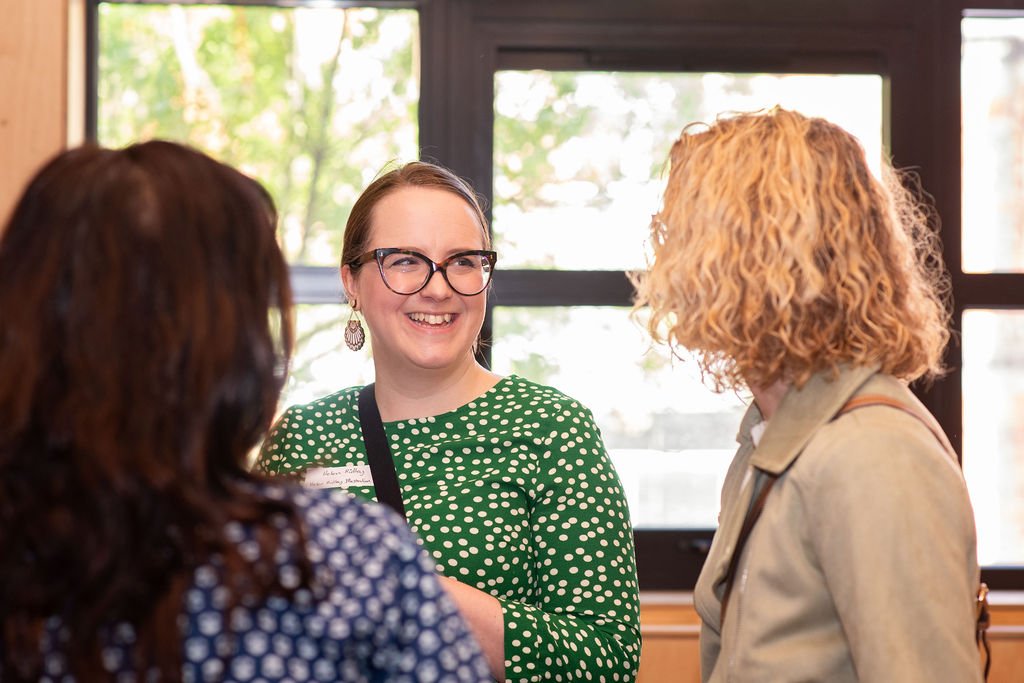 Illustrator Helen Ridley smiling and talking to guests at the creative networking event in Reading