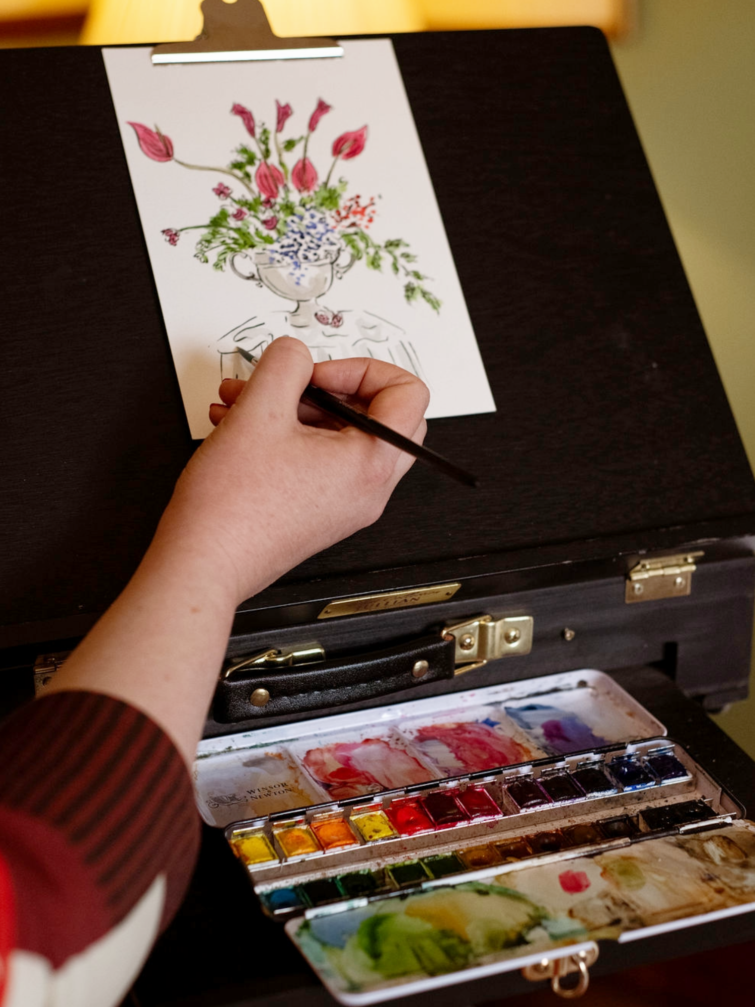 Helen Ridley painting florals at an easel with watercolour paints 