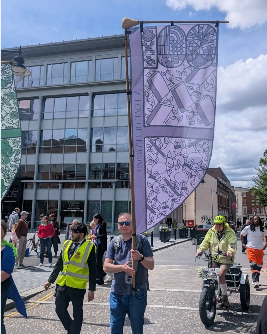 Purple flag being carried through Reading University Centenary parade illustrated by Helen Ridley