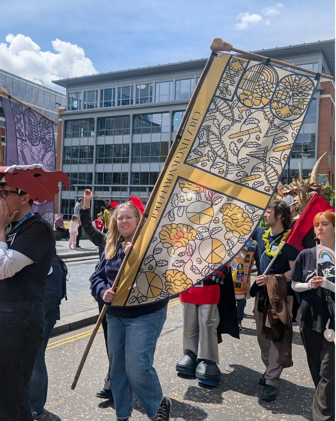 Woman carrying yellow centenary flag through reading for university