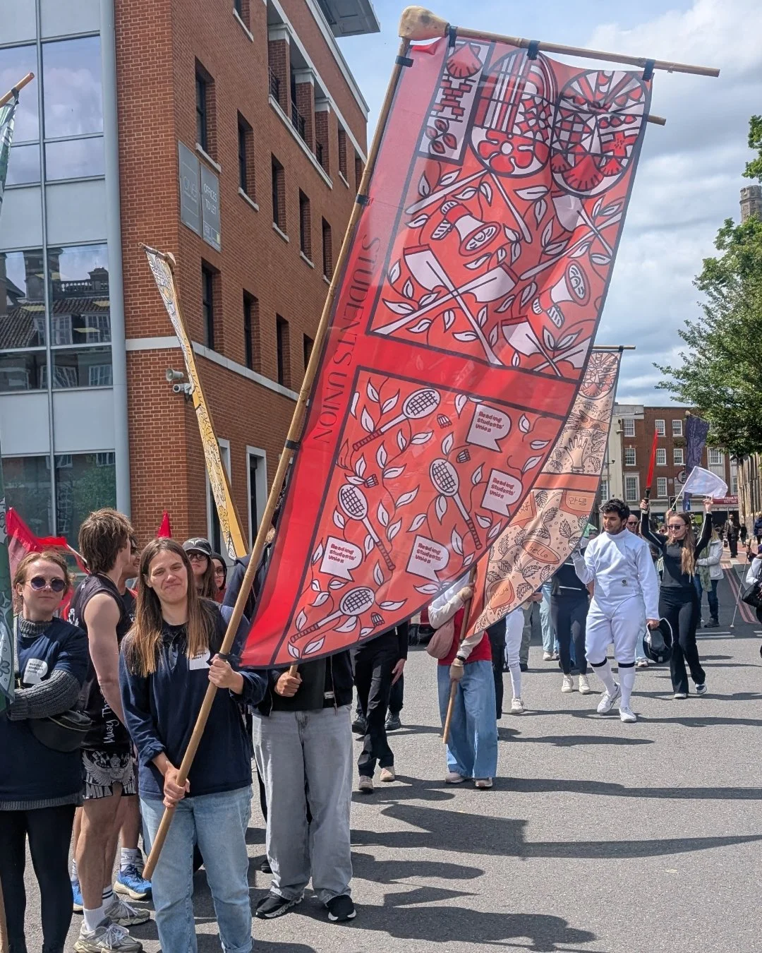Man carrying red centenary flag illustrated by Helen Ridley