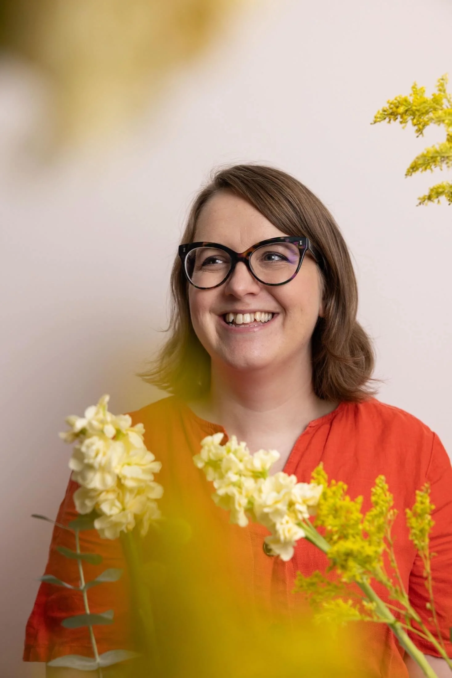 Helen Ridley smiling, surrounded by yellow flowers