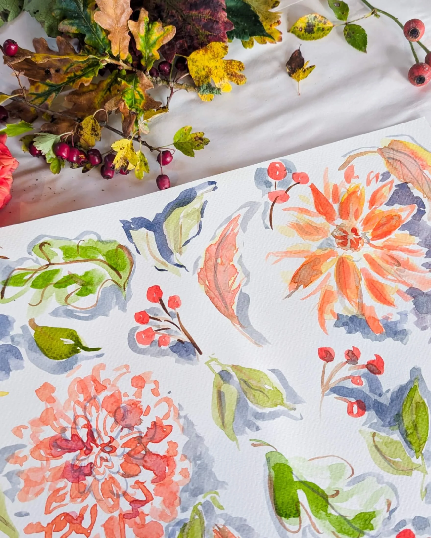A sketchbook with watercolour images of autumn florals