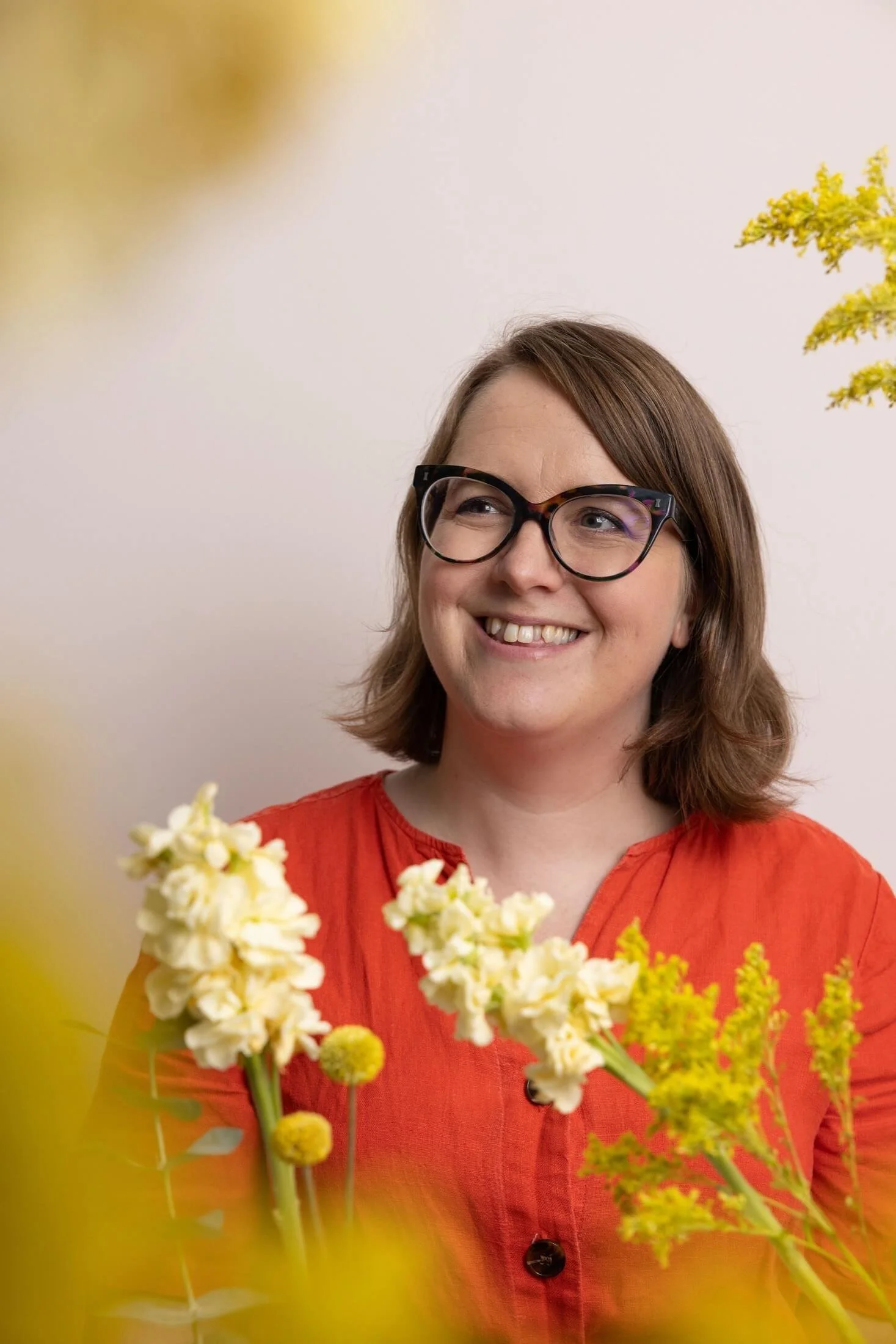 Helen Ridley smiling, surrounded by yellow flowers