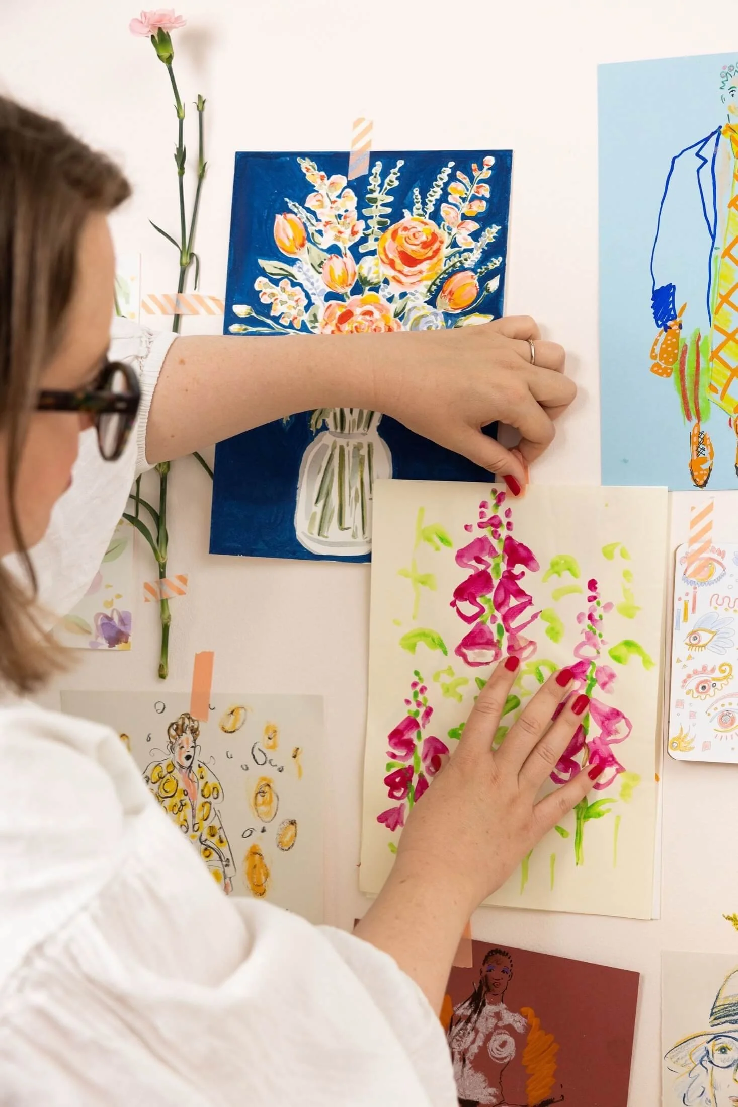 Helen Ridley pinning floral illustrations to a wall
