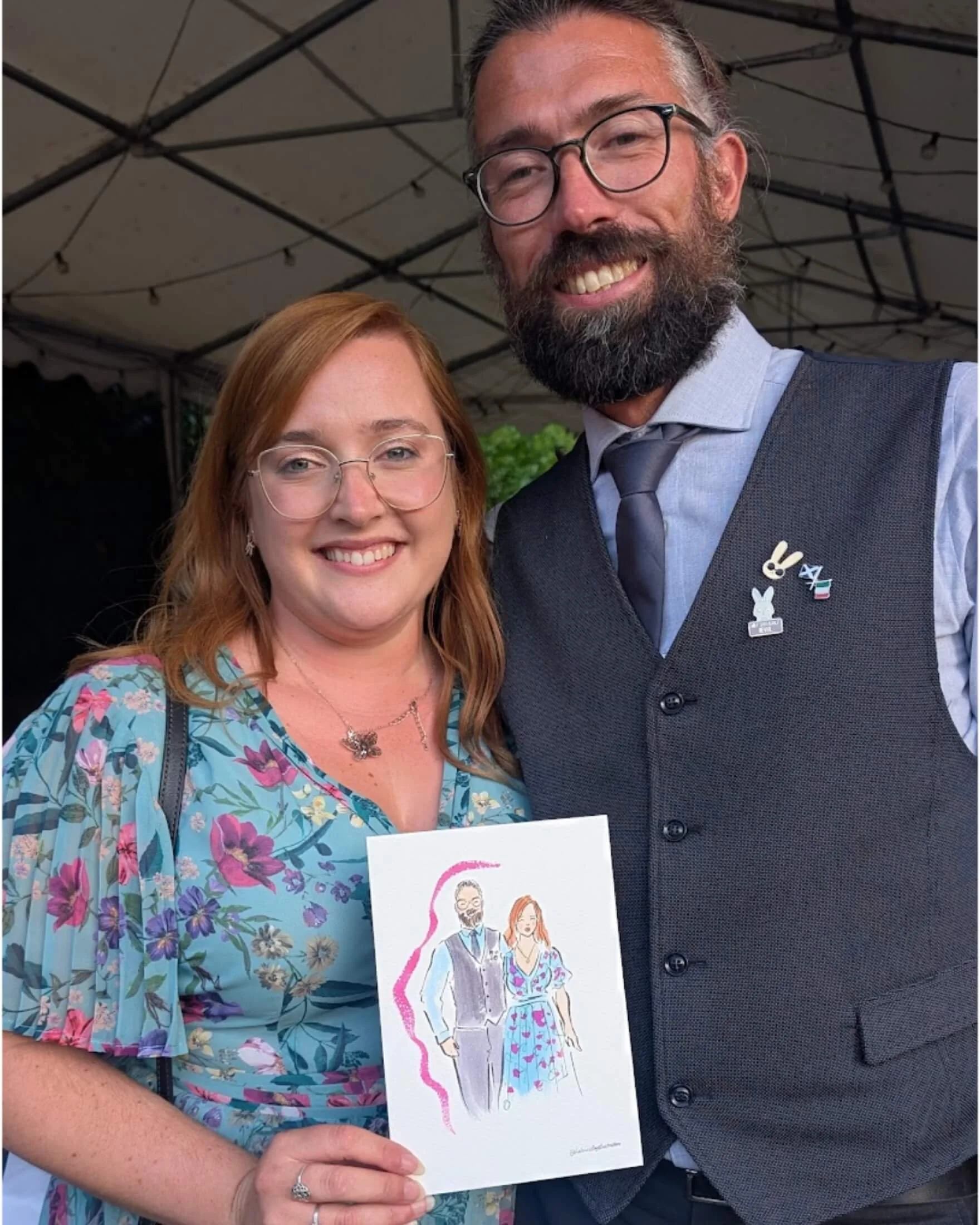Couple at a wedding holding a live illustration of themselves