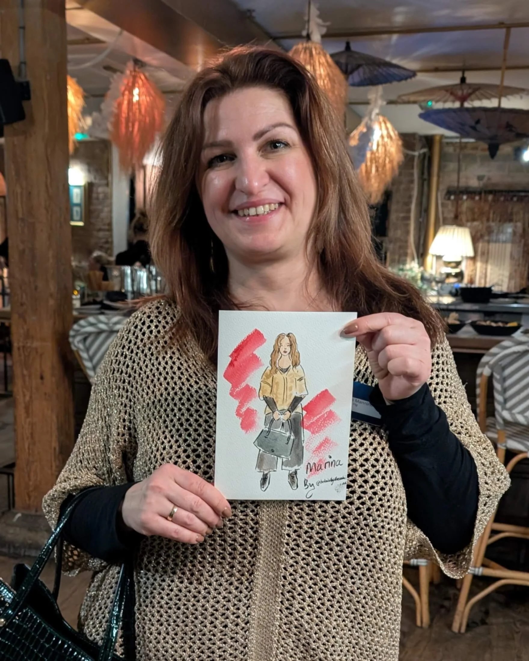 Woman holding a watercolour illustration of herself