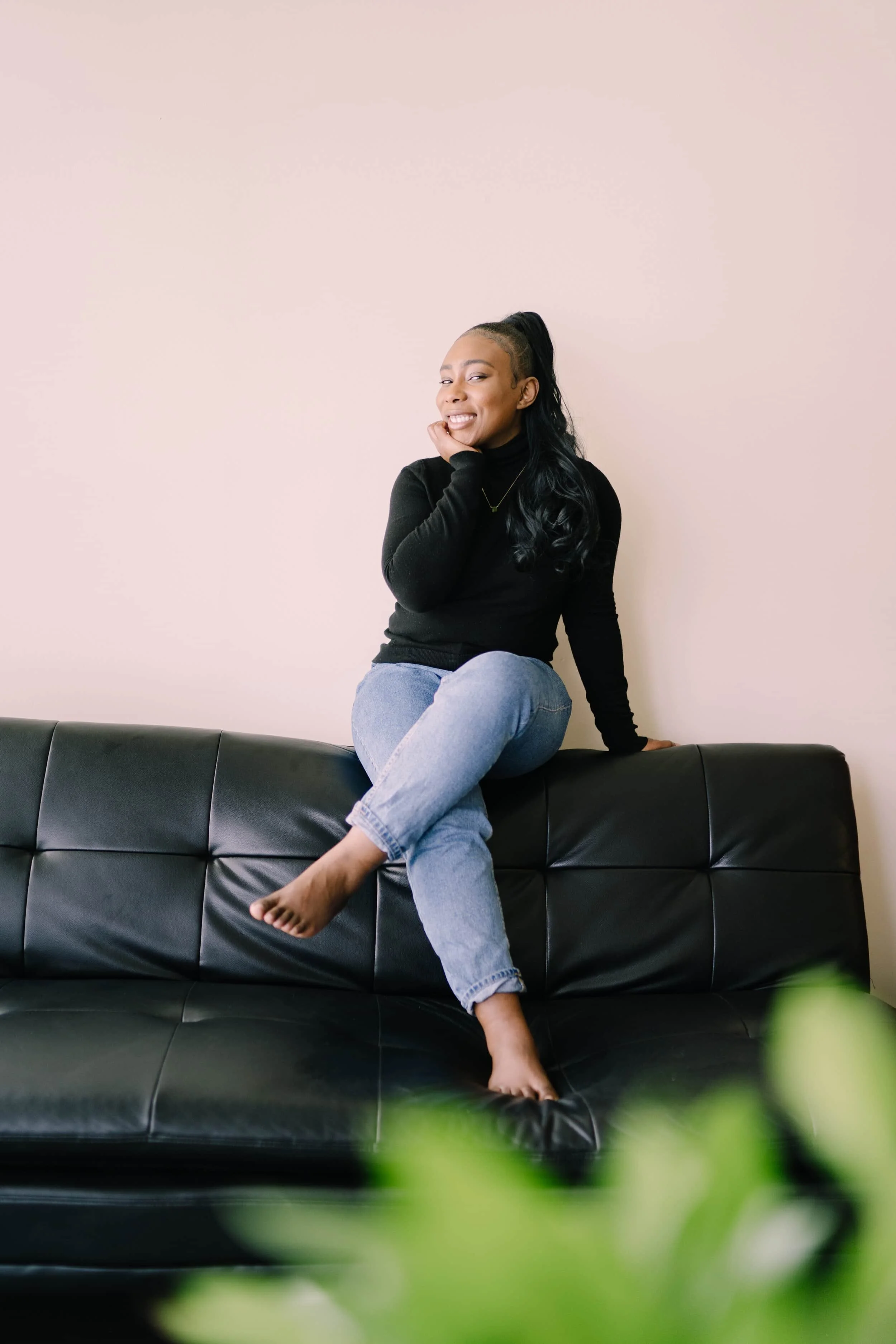 image of site owner Morgan Blackman sitting with one leg crosses on top of a black couch