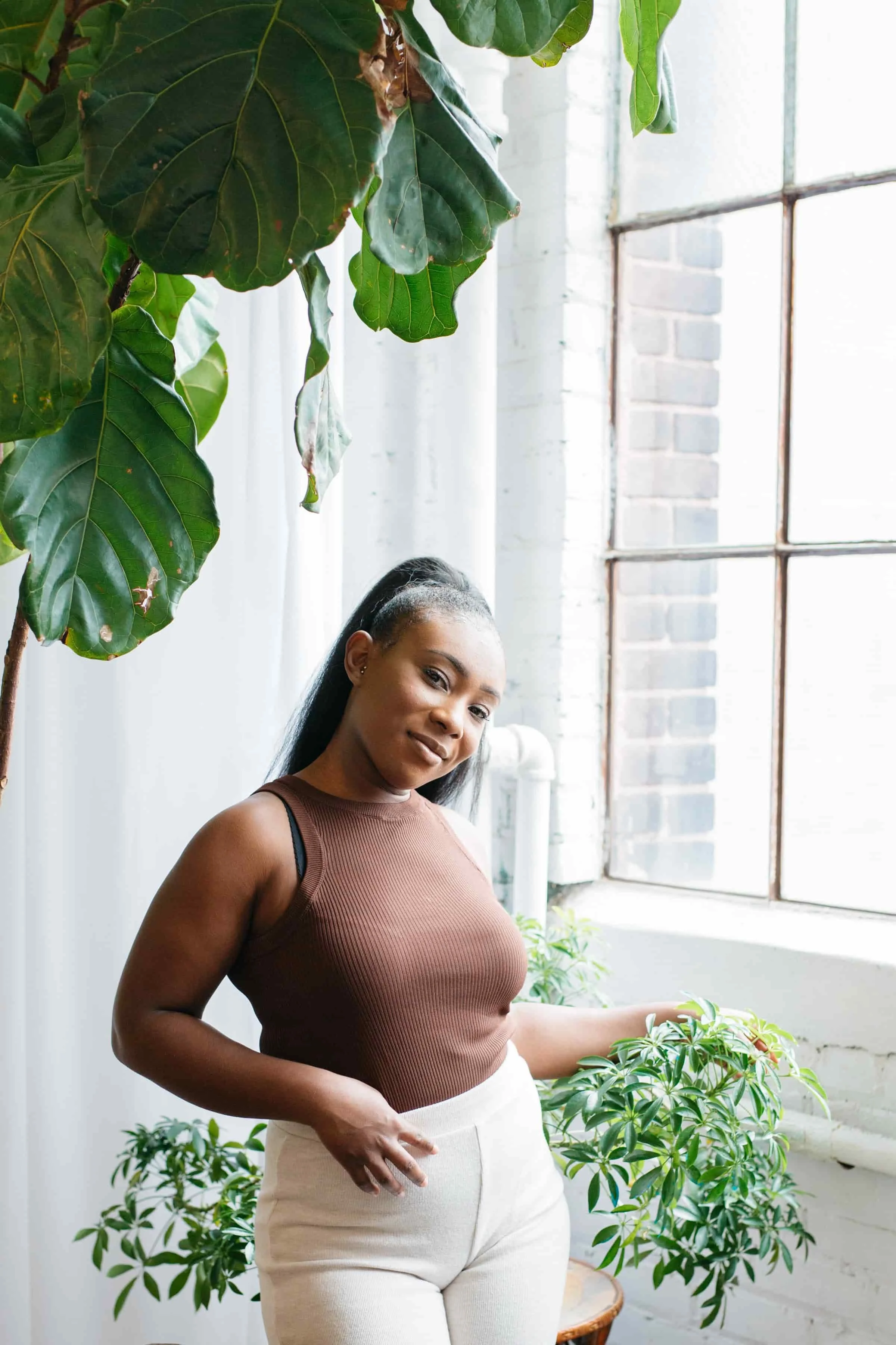 professional image of site owner and coach Morgan Blackman lightly touching plant surrounding her