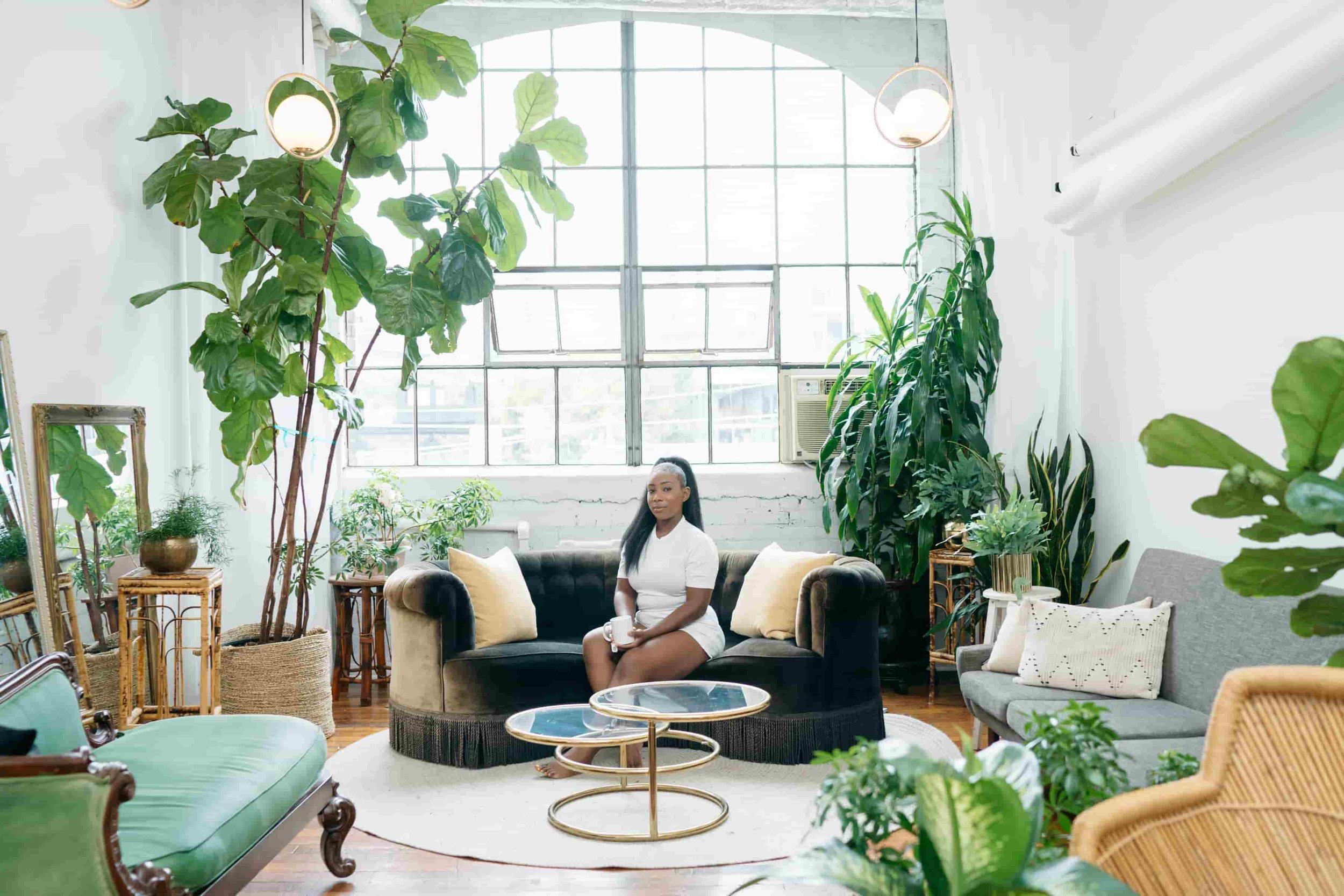 Image of financial wellness coach Morgan Blackman in plant filled studio