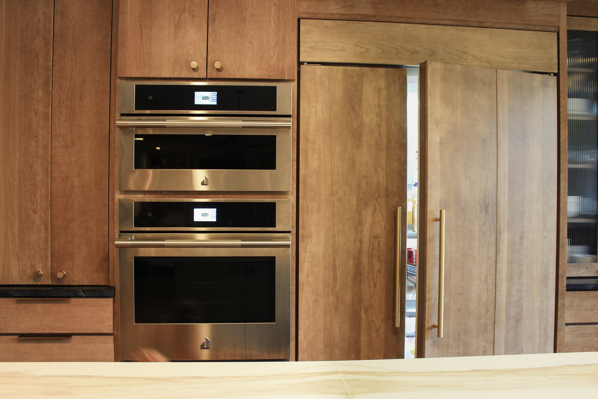 Kitchen renovation with builtin ovens and large cabinet front refrigerator