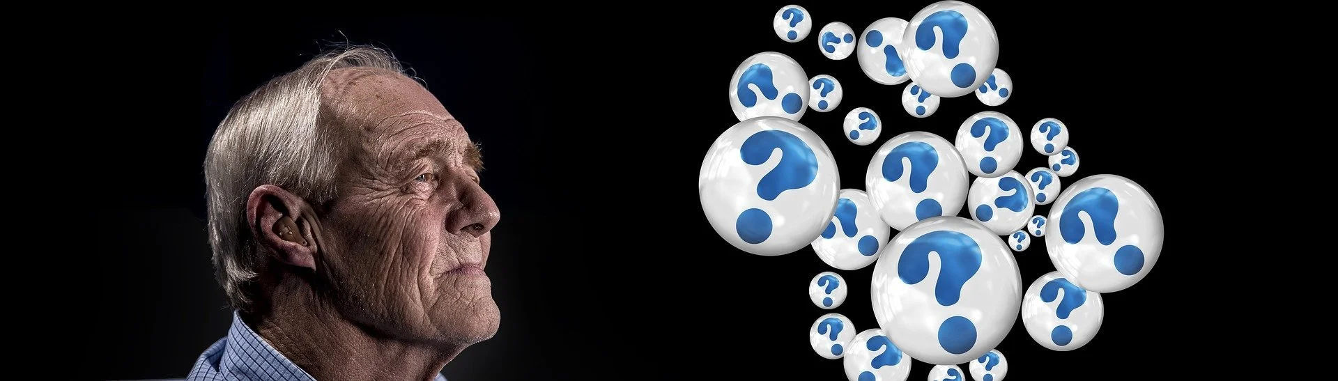 Older man with white hair on the left facing right, with a cluster of white spheres with blue question marks floating on the right side against a black background.