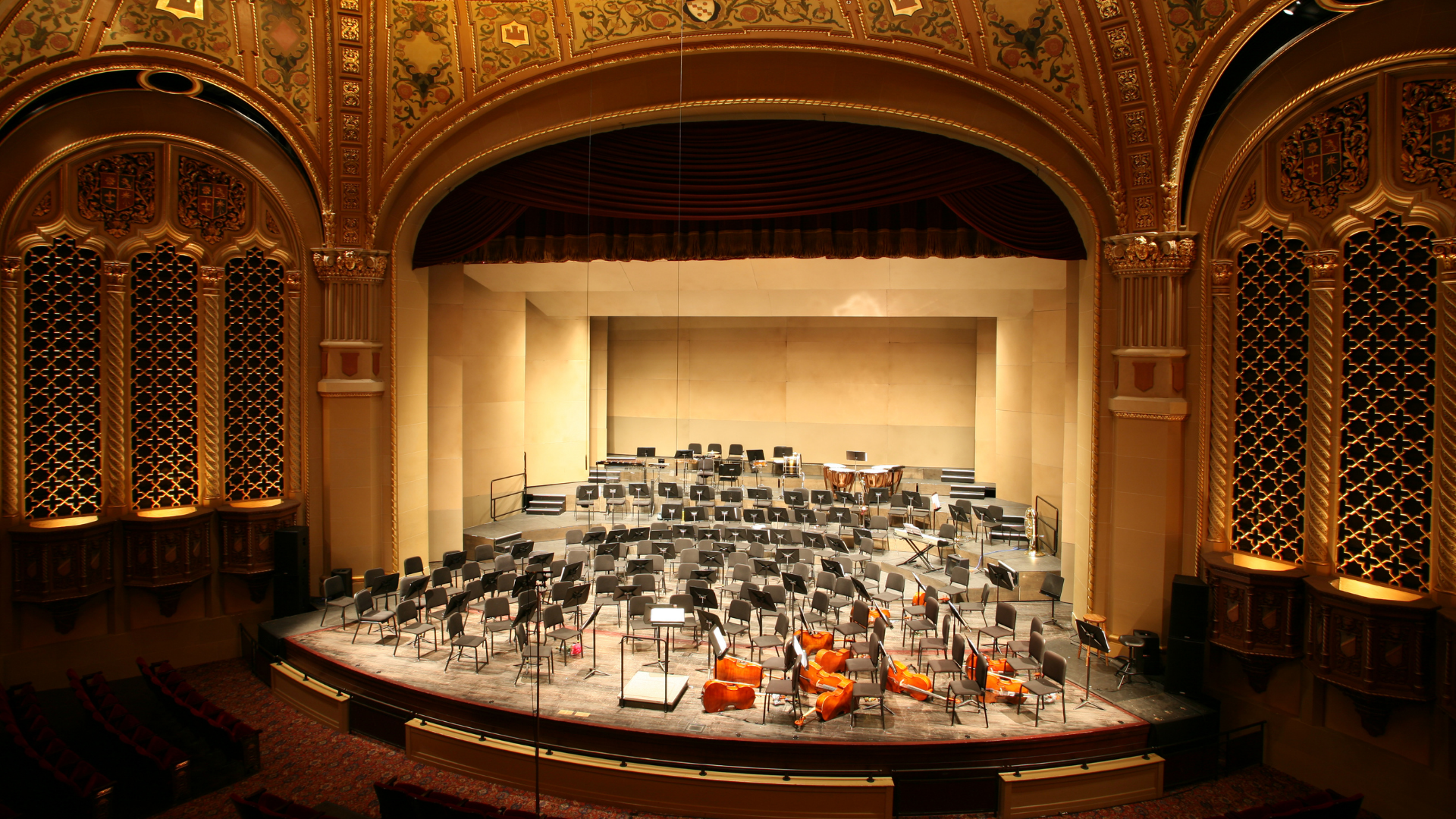 formal concert hall setup with instruments and orchestra seats on stage
