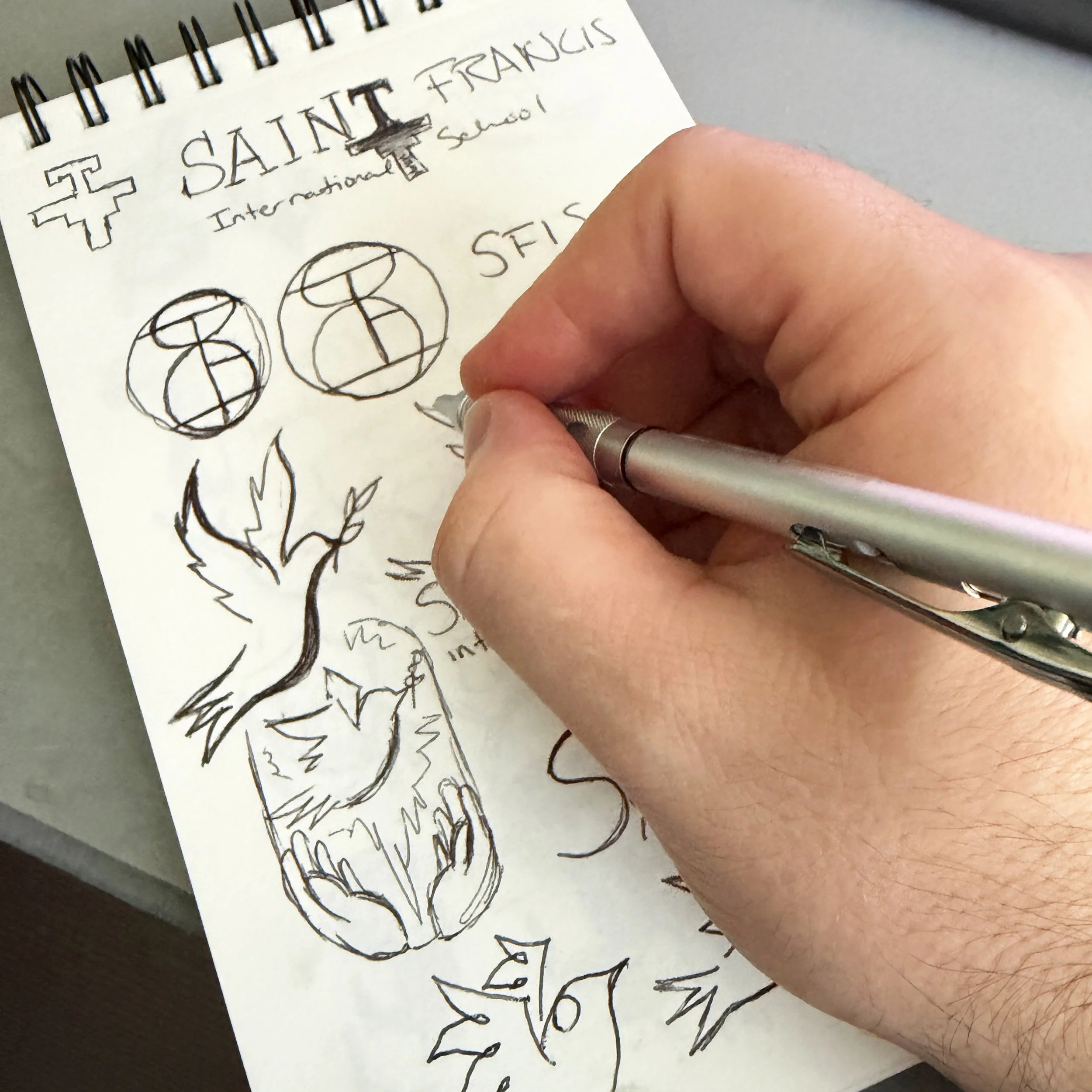 Kevin's artist hand brainstorming sketches for logo