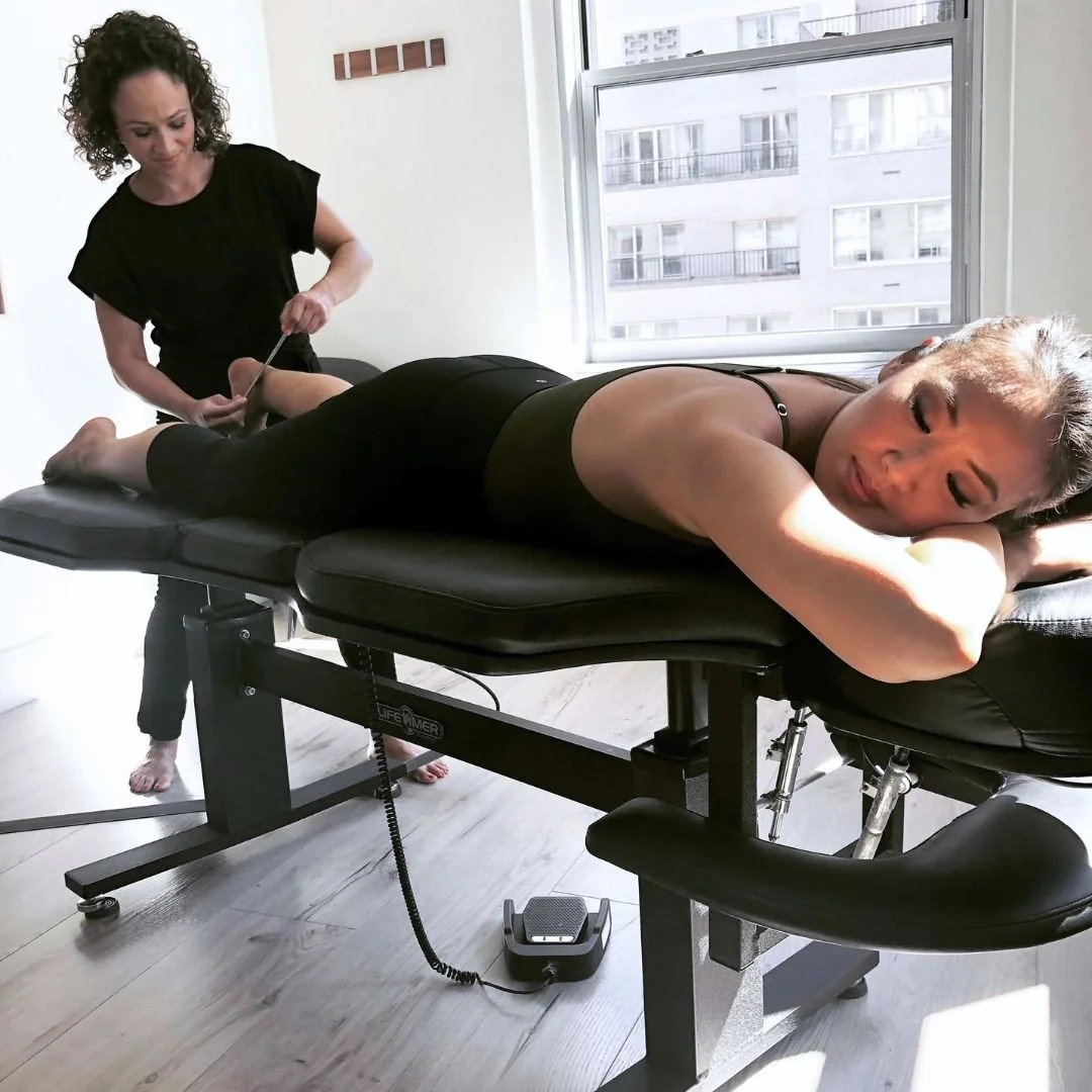 Bethany Vivo in her studio treating a client with a full body assessment and hands-on work.