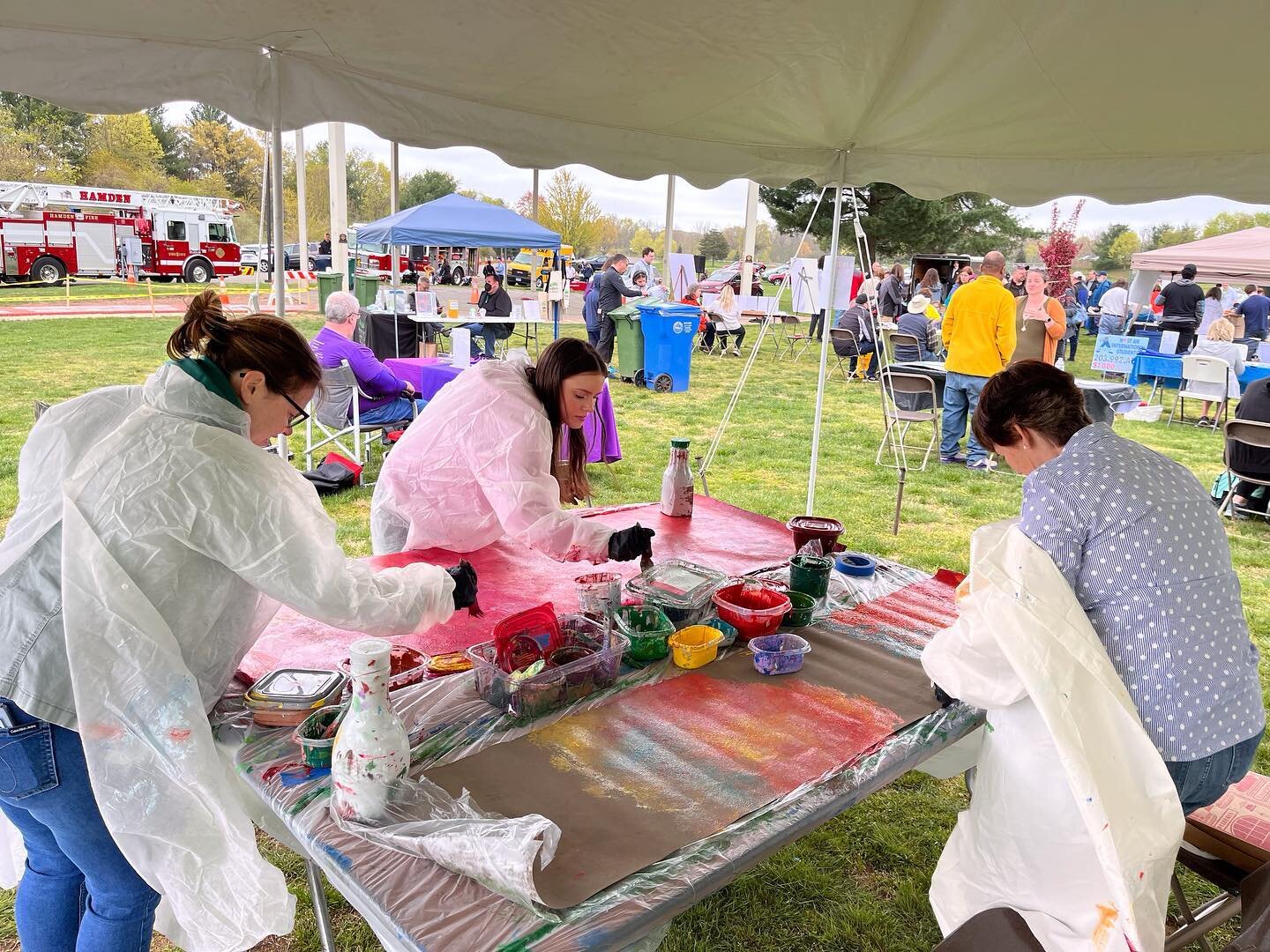 The MLK39 Racial Equity mural community paint day in Hamden. At the Earth Day celebration, we set up a few tables with prepped Polytab for the mural. 61 participants painted 14 book spines for the library mural. The next community paint day will be o
