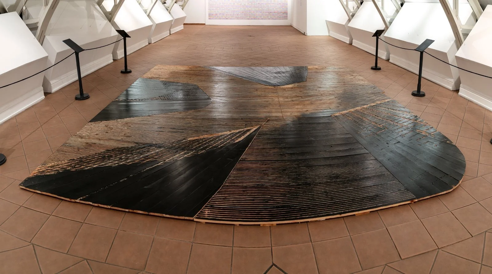 Detailed floor view of carved wood panels in USA Diary woodcut installation by artist Gábor Koós.