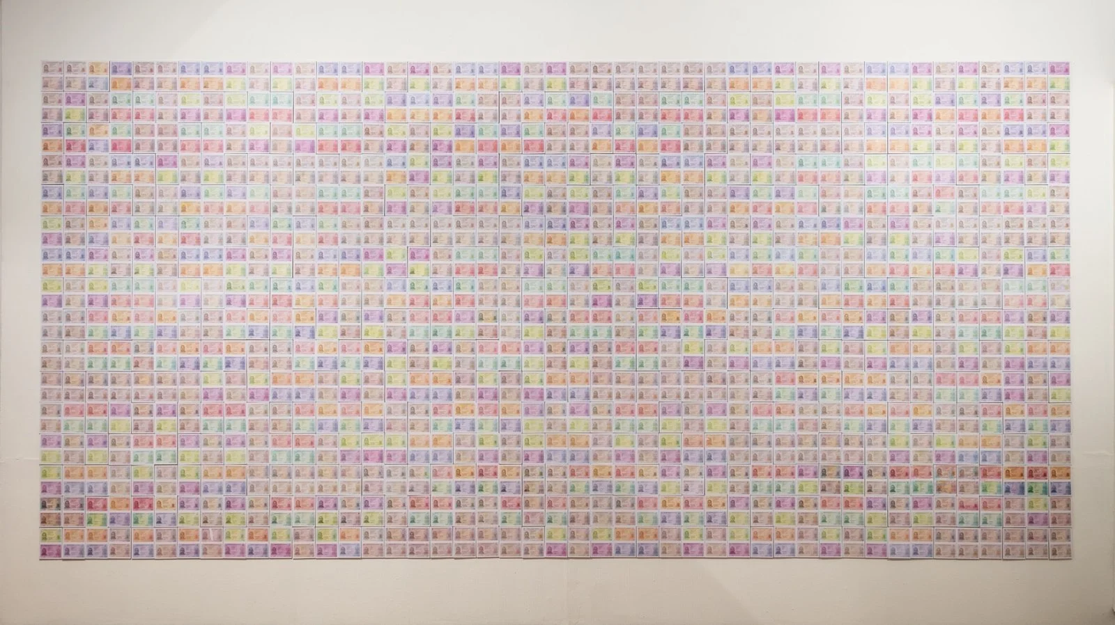 Panoramic view of a wall covered in altered ID prints, by artist Gábor Koós.