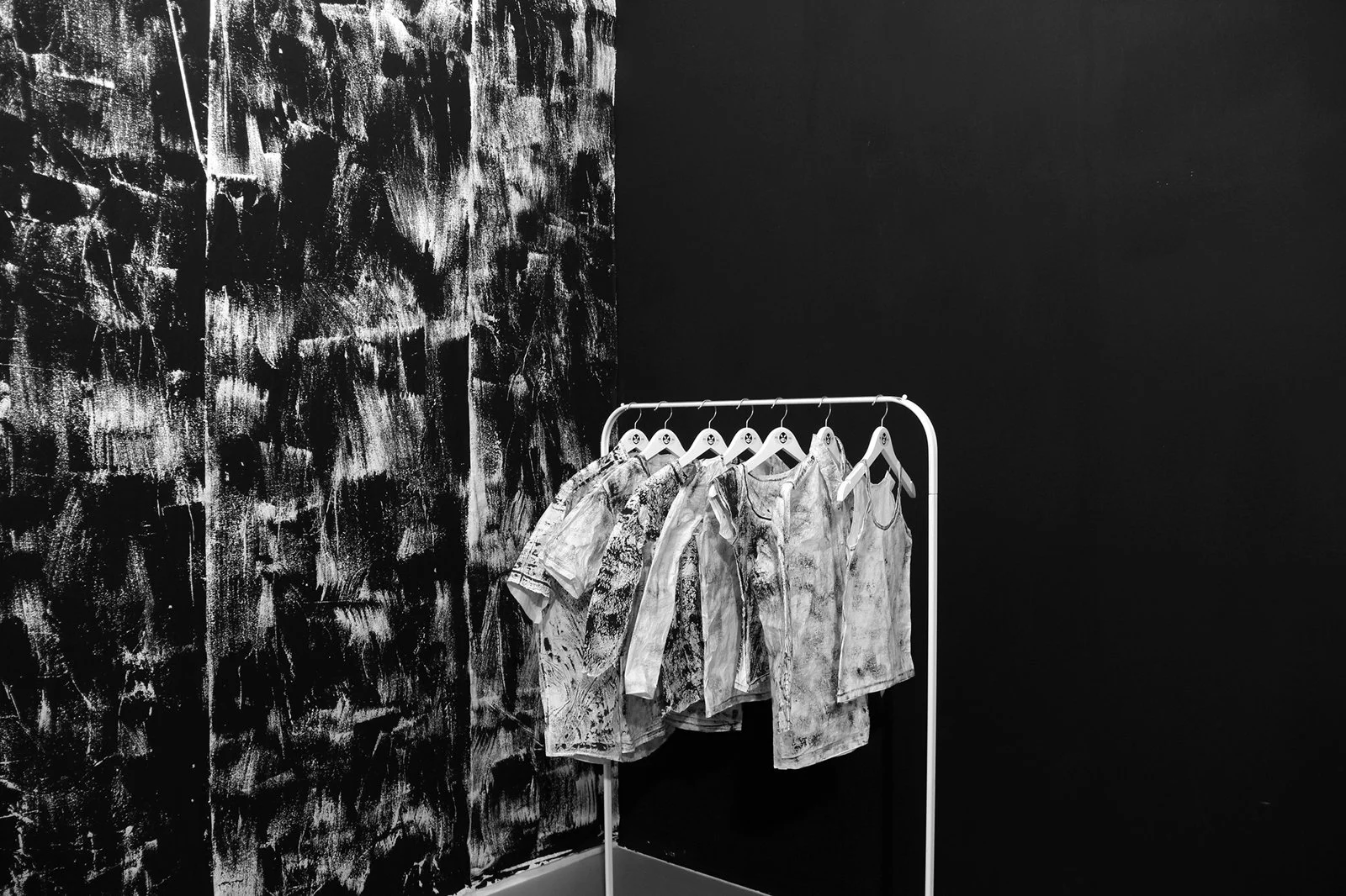 Close-up of Gábor Koós’s frottage-printed garments on hangers, part of his time-themed art installation at LLPlatform.