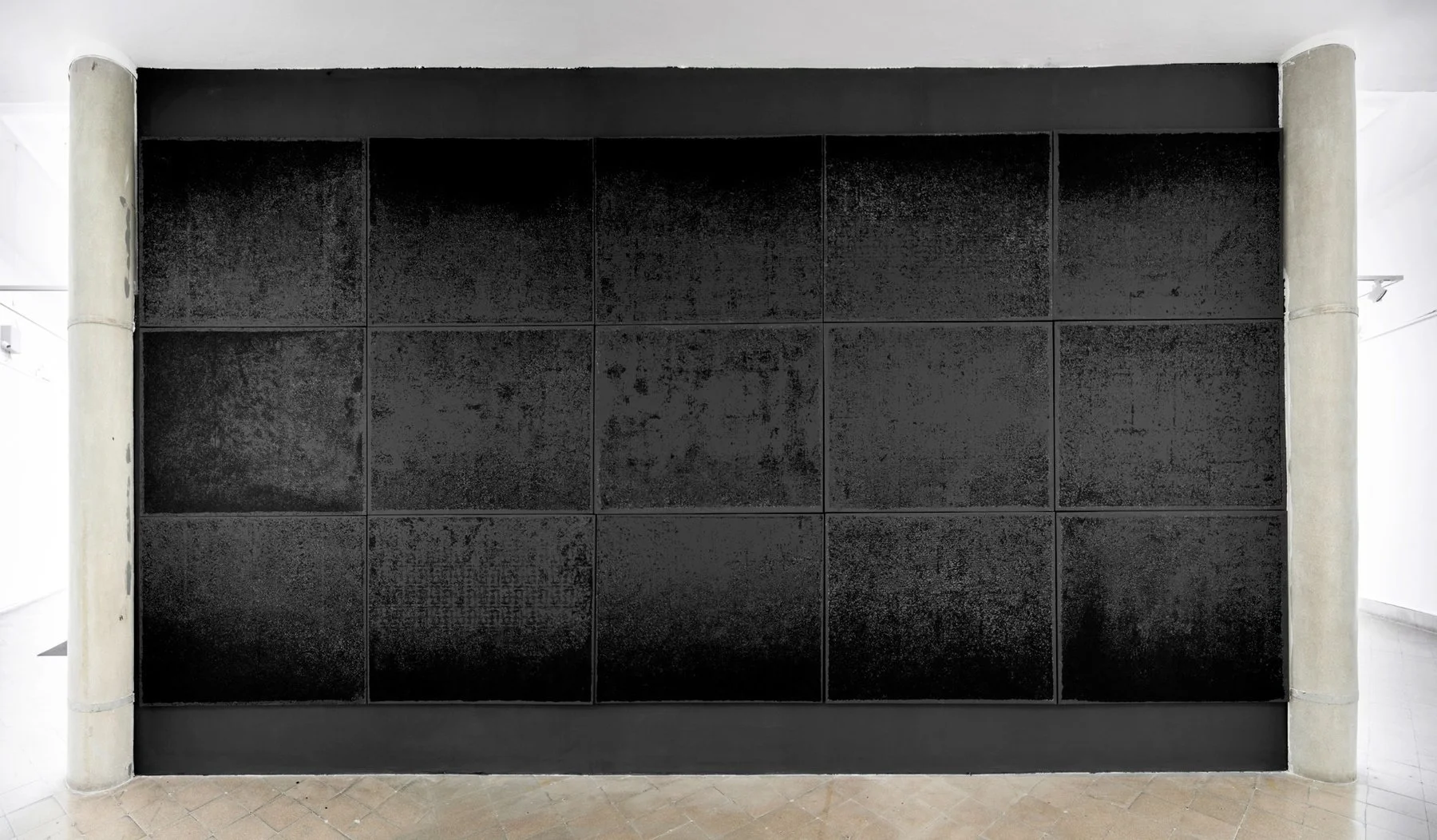 Side view of blackened wall facing a sunlit architectural environment, part of the Gazing into Darkness installation.