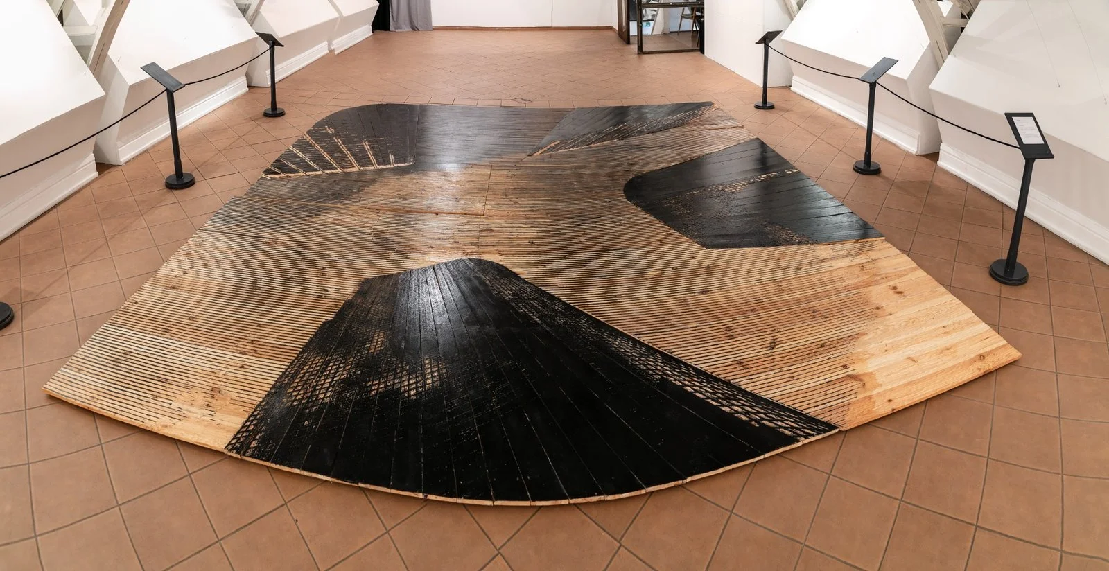 Close-up of expansive woodcut flooring with architectural motifs by Gábor Koós, USA Diary.