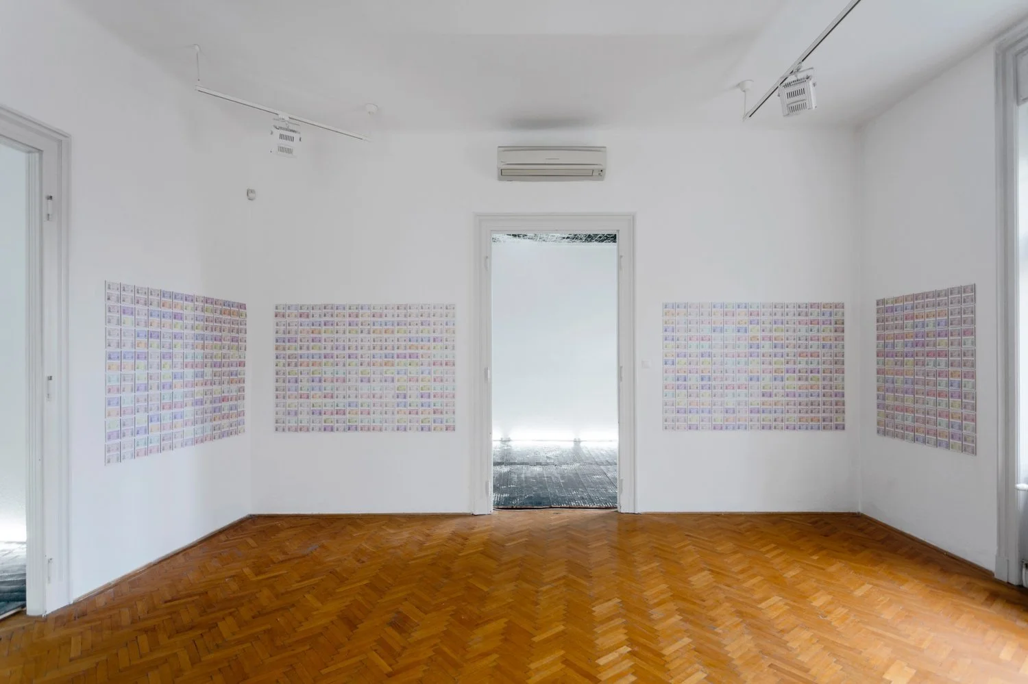 Interior exhibition shot with installation of Gábor Koós’ ID card wall works and adjoining woodcut floor printscape