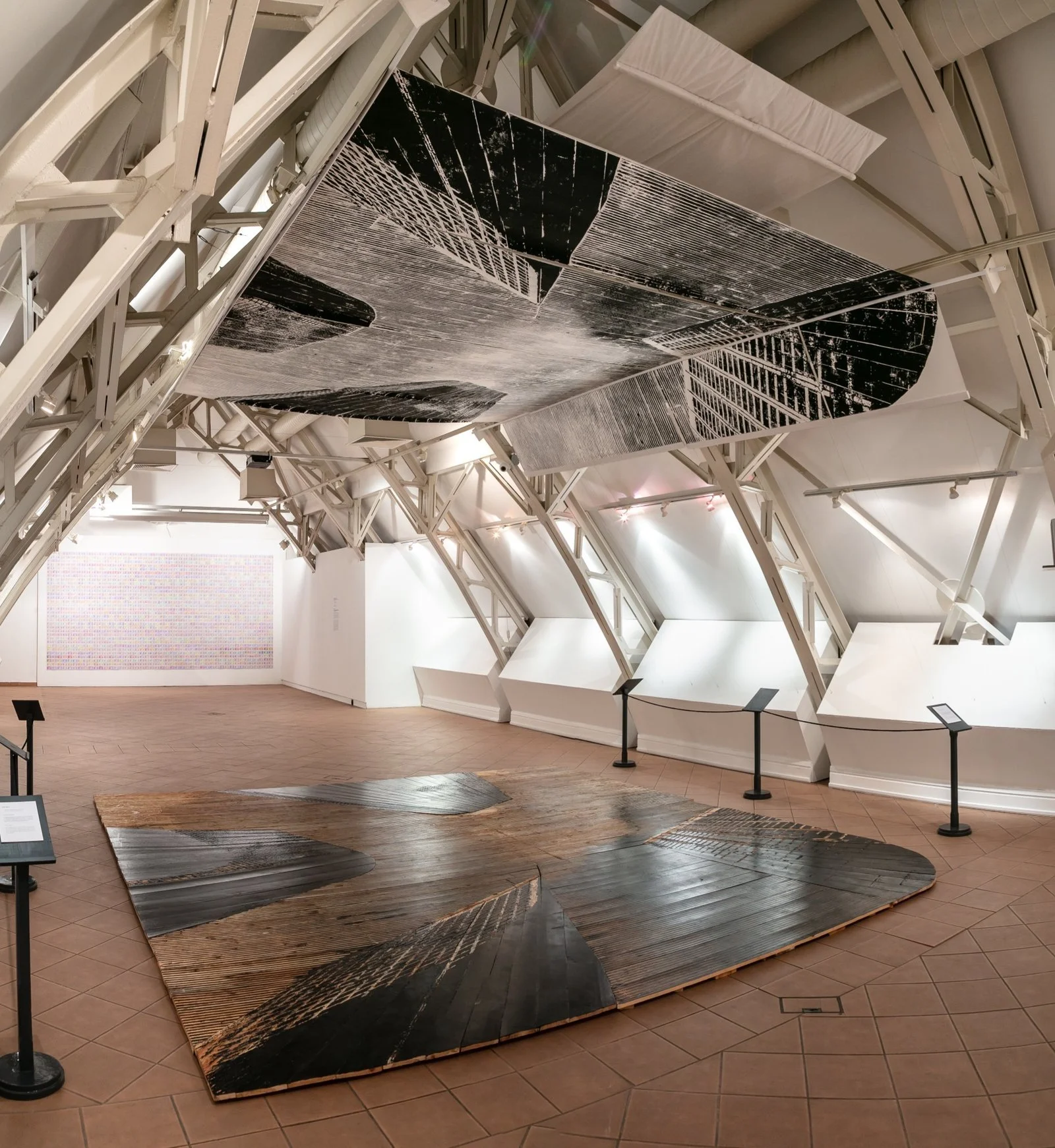 Panoramic view of installation room with floor-to-ceiling woodcut prints by Gábor Koós, USA Diary.