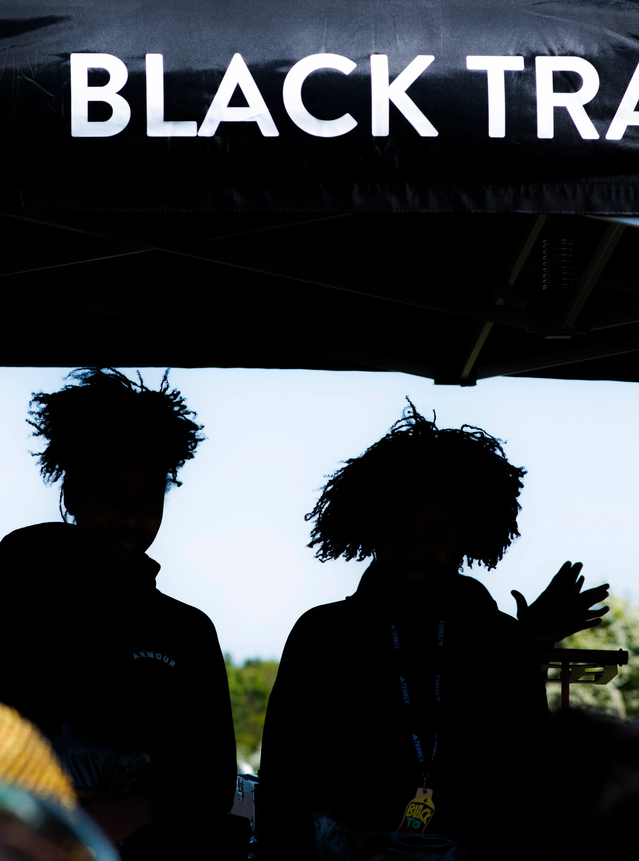 silhouette of two young people at a trail race finish line