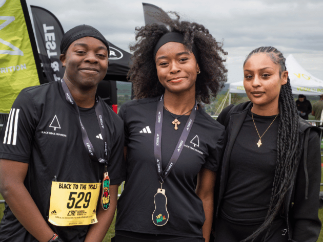 Three young people wearing medals for trail racing