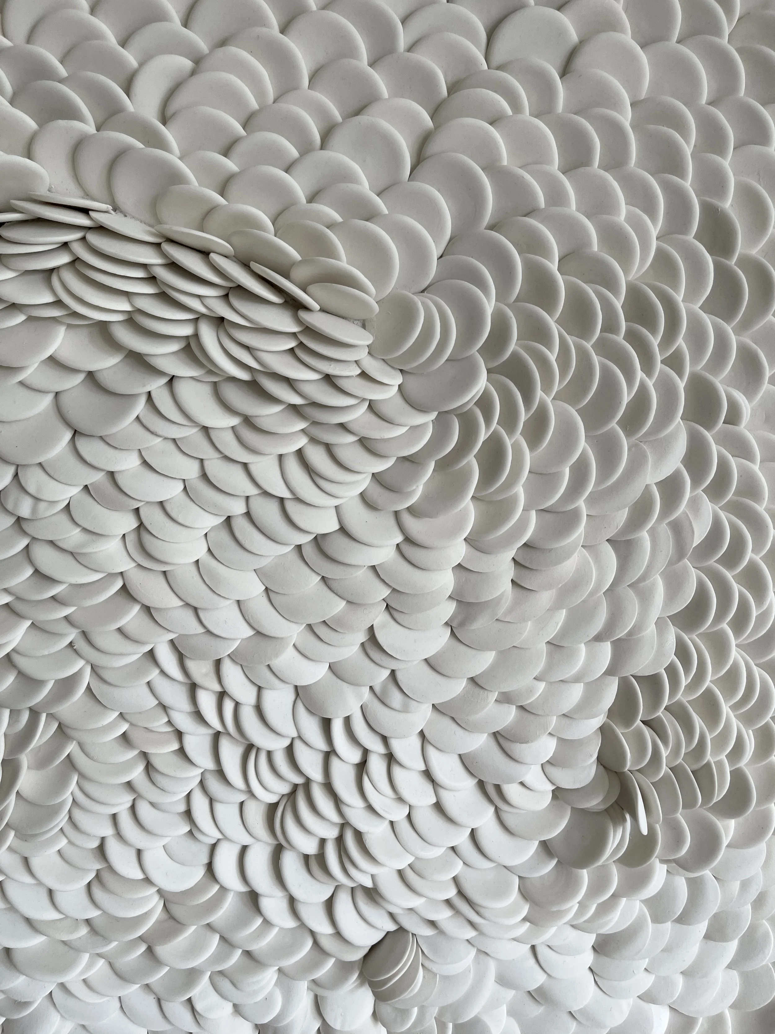 Natural light illuminating the sculptural porcelain surface, revealing gentle shadows and flowing movement across the composition.