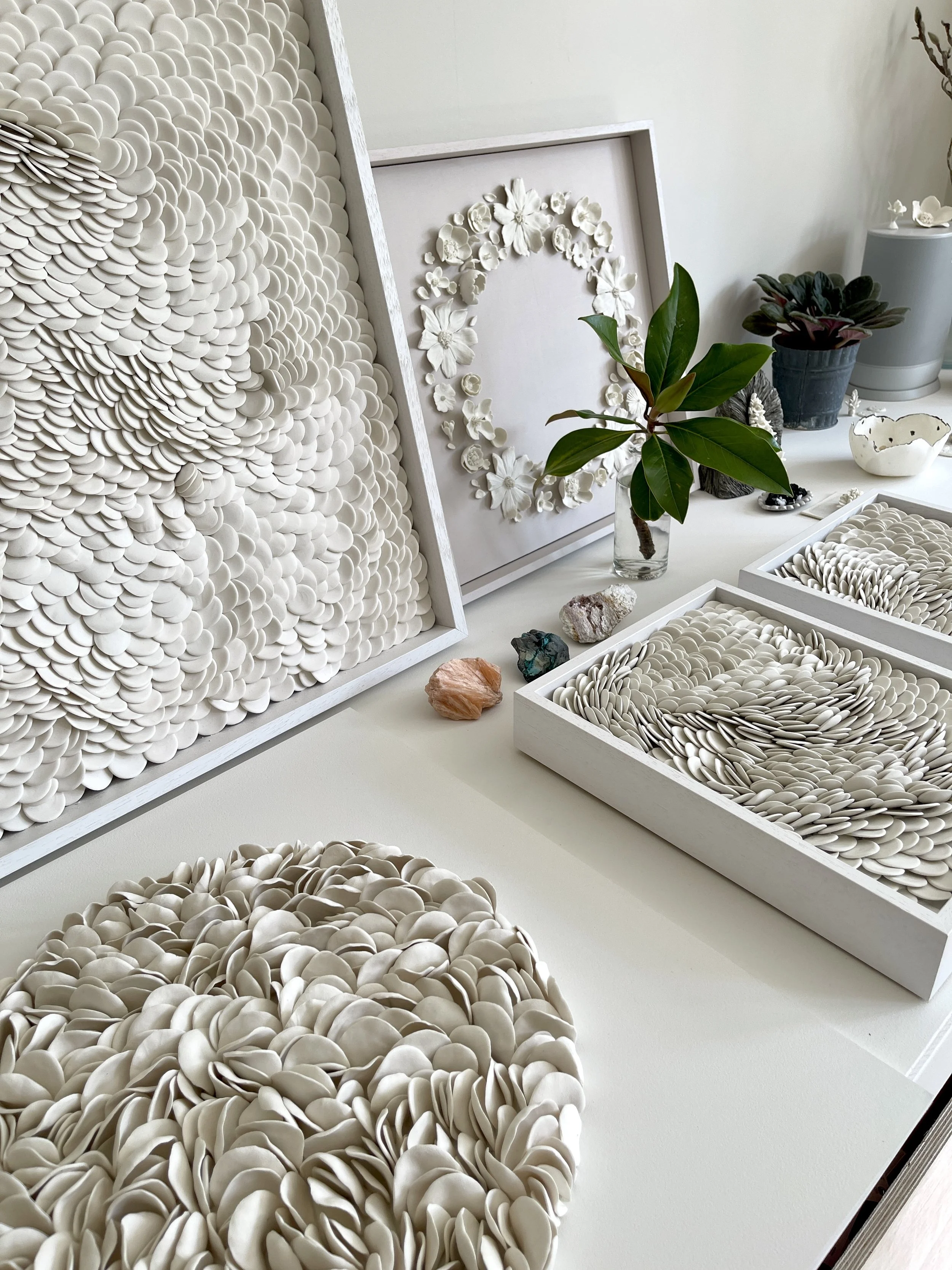 Studio view of contemporary porcelain wall sculptures exploring repetition, texture and the meditative relationship between light, material and form.