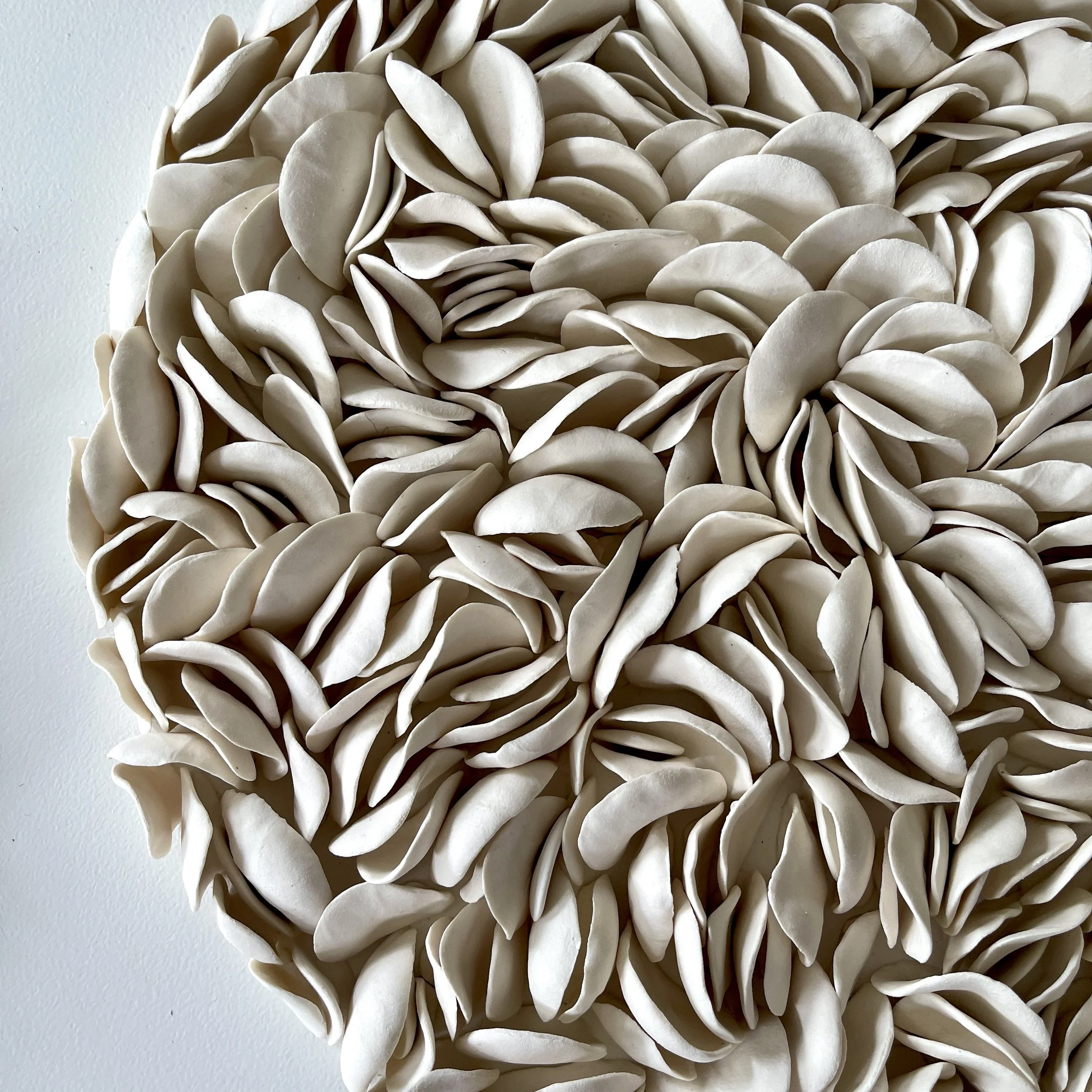 Close-up of Blooming showing individually hand-formed unglazed porcelain elements layered to create rich sculptural texture.