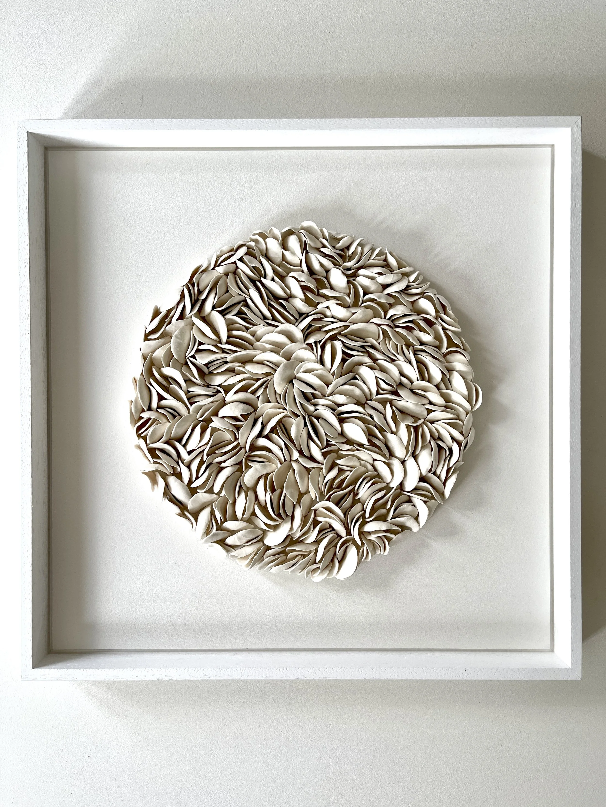 Blooming displayed within a white floating frame, showcasing the sculptural depth of the handcrafted porcelain artwork.
