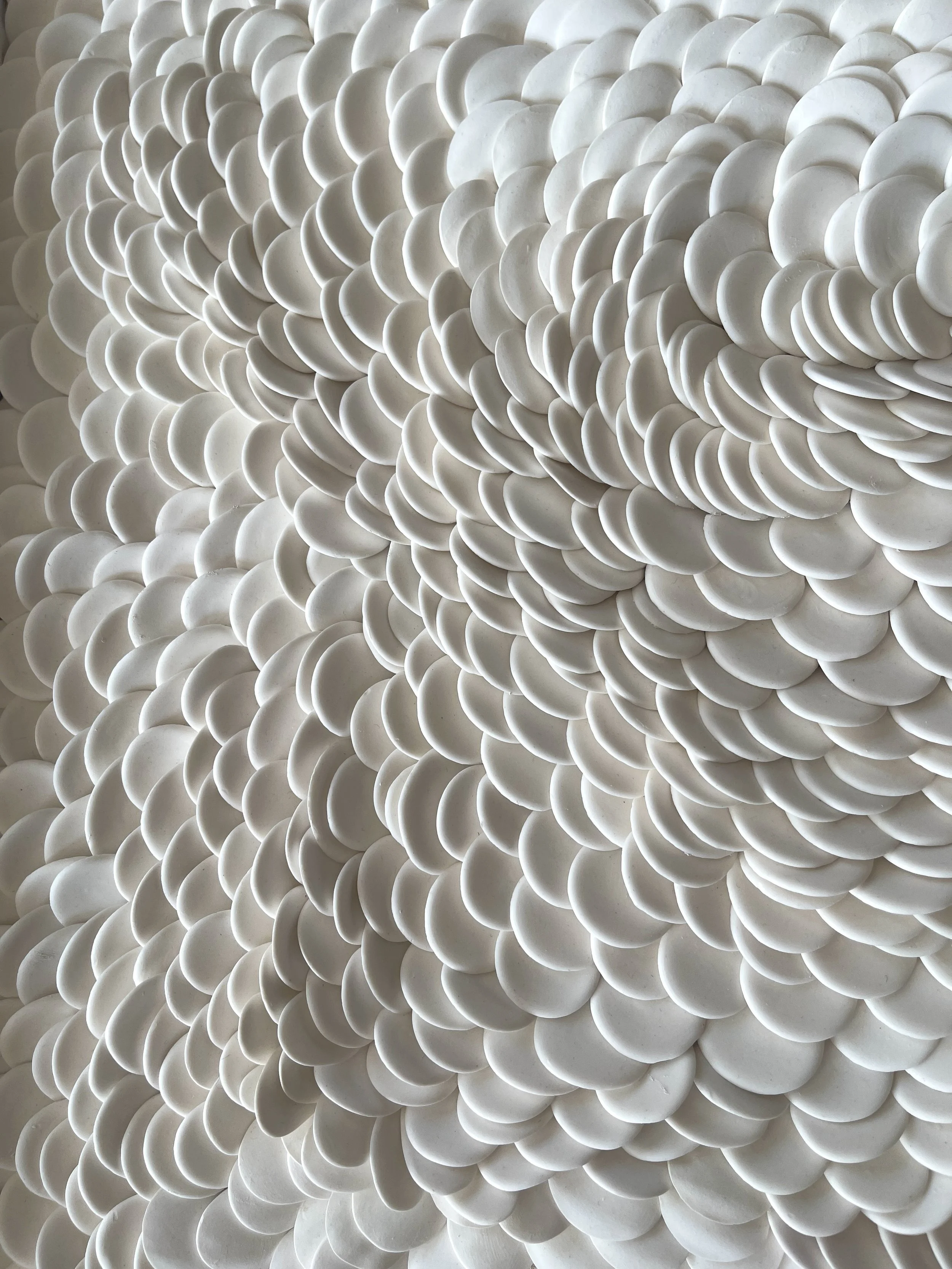 Three-quarter view revealing how the layered porcelain elements capture and soften natural light throughout the sculpture.