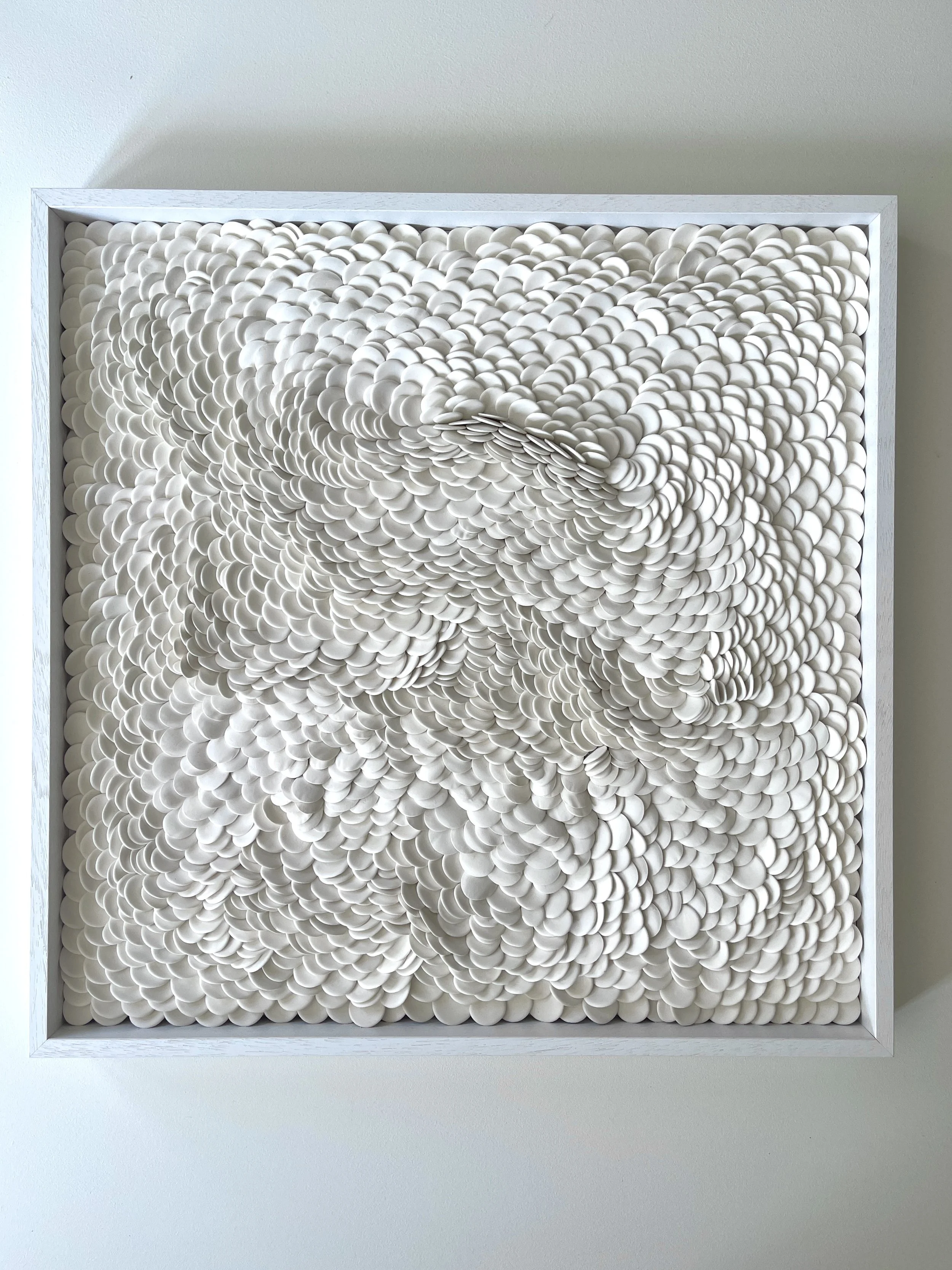 Reflections 5, a contemporary porcelain wall sculpture composed of thousands of individually hand-formed unglazed porcelain elements arranged in a flowing sculptural composition.