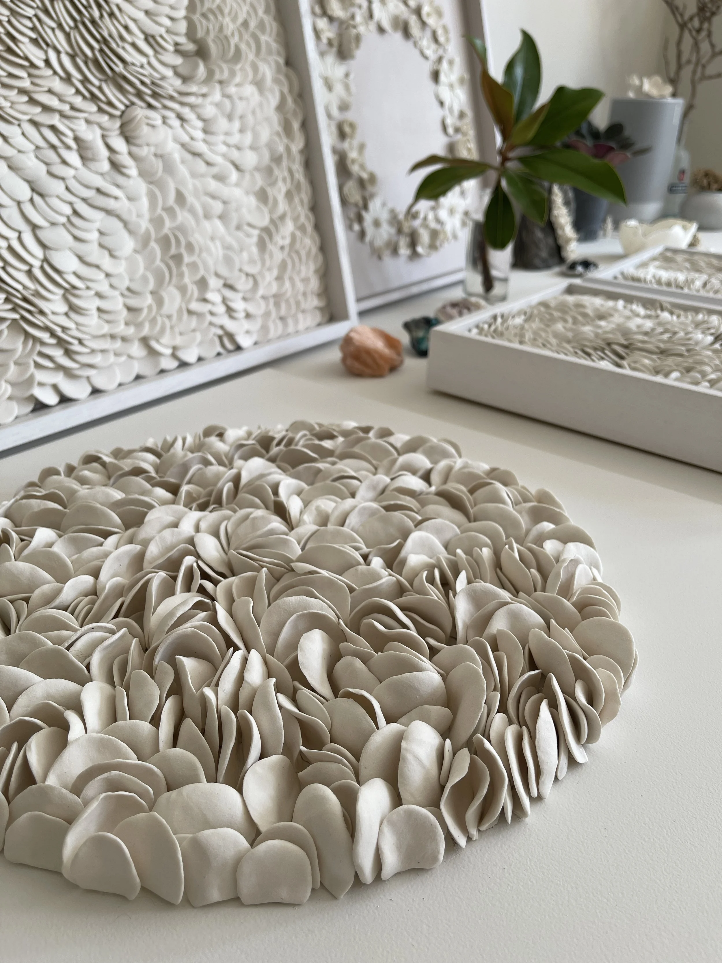 Angled view of Blooming highlighting the depth and flowing movement of layered porcelain elements, within an artists studio.