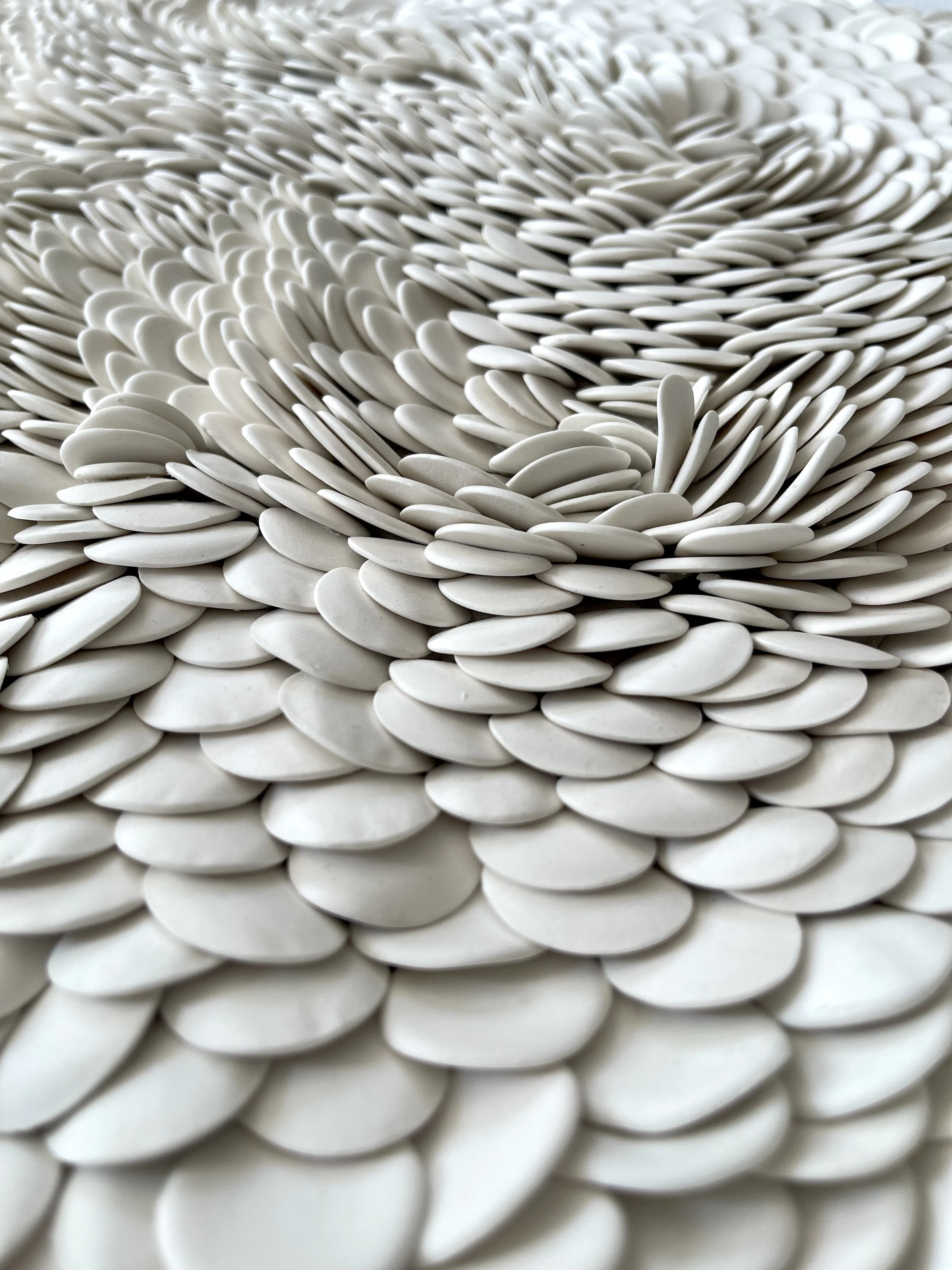 Macro detail showing the undulating rhythm and natural matte finish of unglazed porcelain.