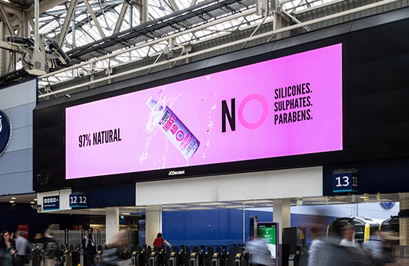 Noughty Haircare product advertised on digital screen at London Waterloo station