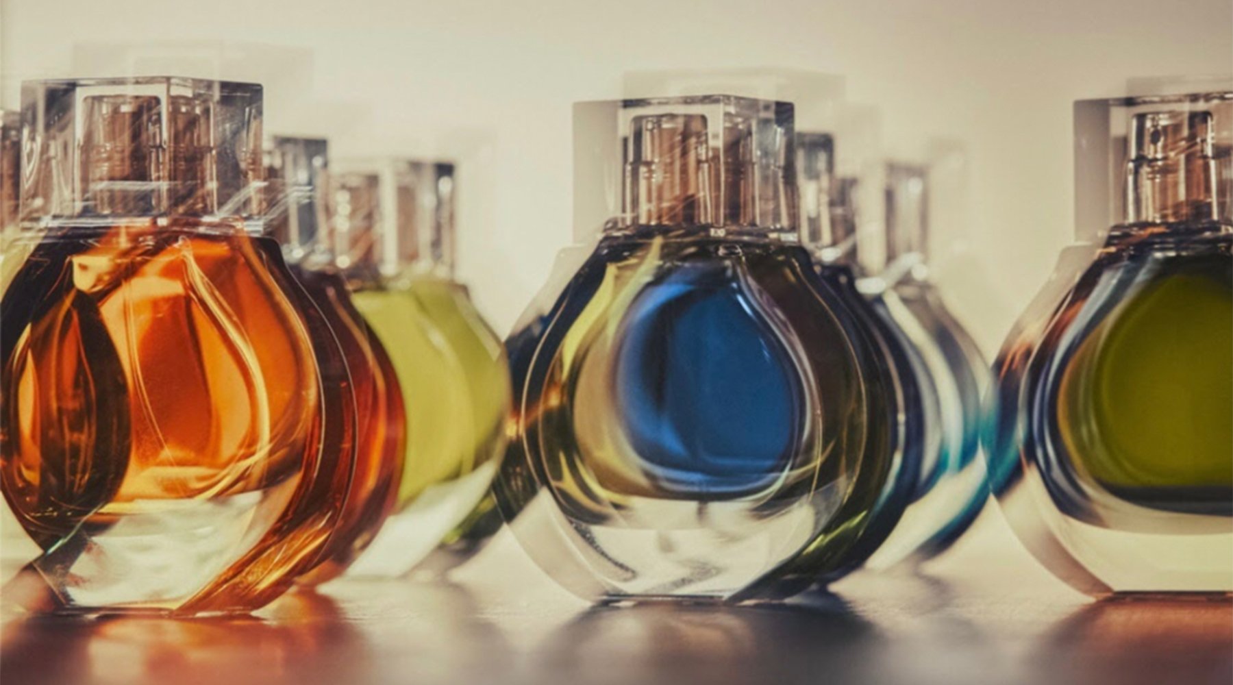 Row of amber, green and blue rounded perfume bottles, Kim Kardashian KKW Fragrance bottle and packaging design