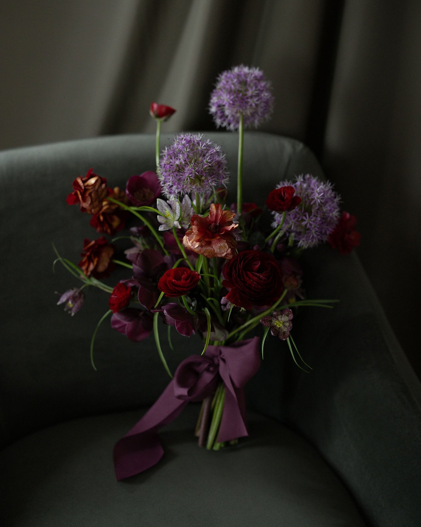 Our favorite bouquets tend to be the ones that feature just a few varieties of flowers en masse. Here: Ranunculus, allium, hellebore and fritillaria in the hands of @virginiaholman. Bridal portraits made by @arealsmith. ❤️💜