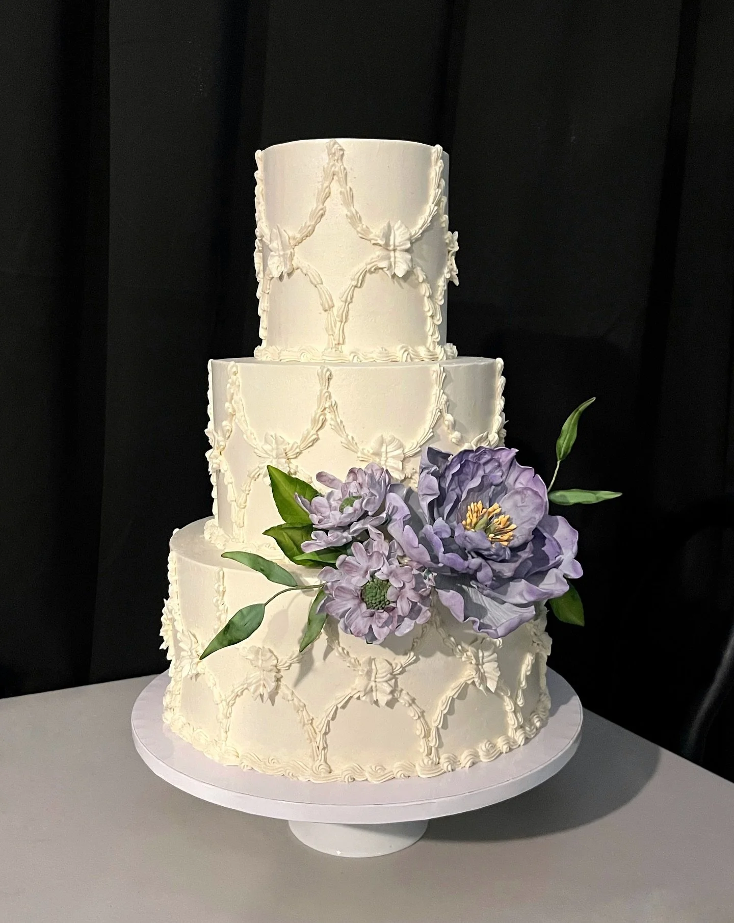 For Elaney and Ivan: Three tiers of vegan cake in two of our best selling flavors (Lemon Blackberry and Seattle Fog), lovingly piped with a vintage quatrefoil design and adorned with a flourish of sugar flowers (peony, scabiosa, and ruscus). I staged
